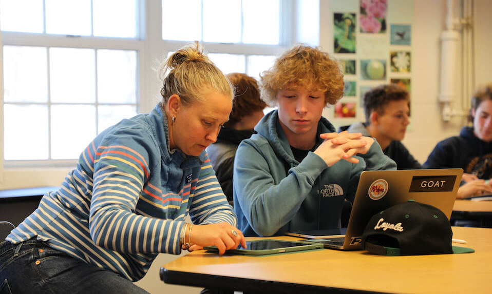 A Proctor student and teacher reviewing info on a tablet.
