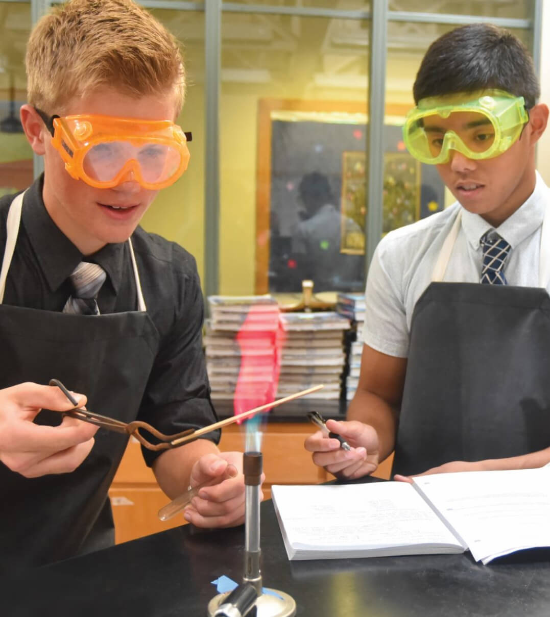 Two St. Johnsbury Academy students conducting an experiment with a bunsen burner.