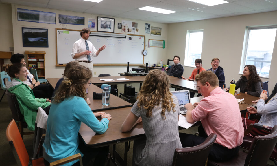 A St. Johnsbury Academy teacher leading a discussion in front of the class.