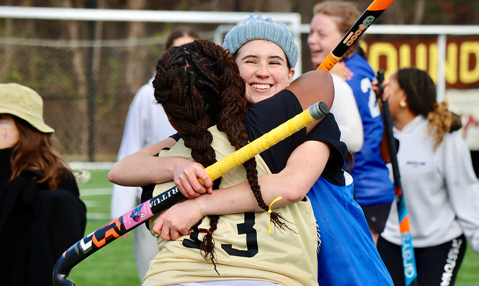 Two Foxcroft School students hugging after a field hockey game in the school's Fox/Hound competition.