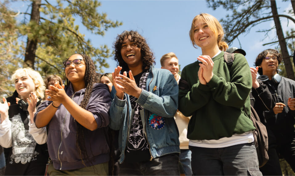 Idyllwild Arts Academy students clapping at an outdoor performance.