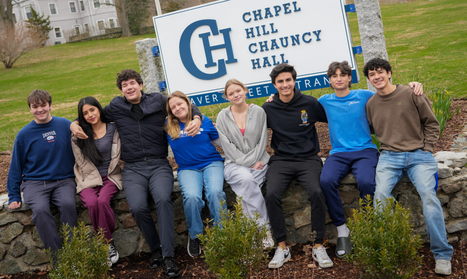 Chapel Hil-Chauncy Hall students posing for a photo in front of the school sign.
