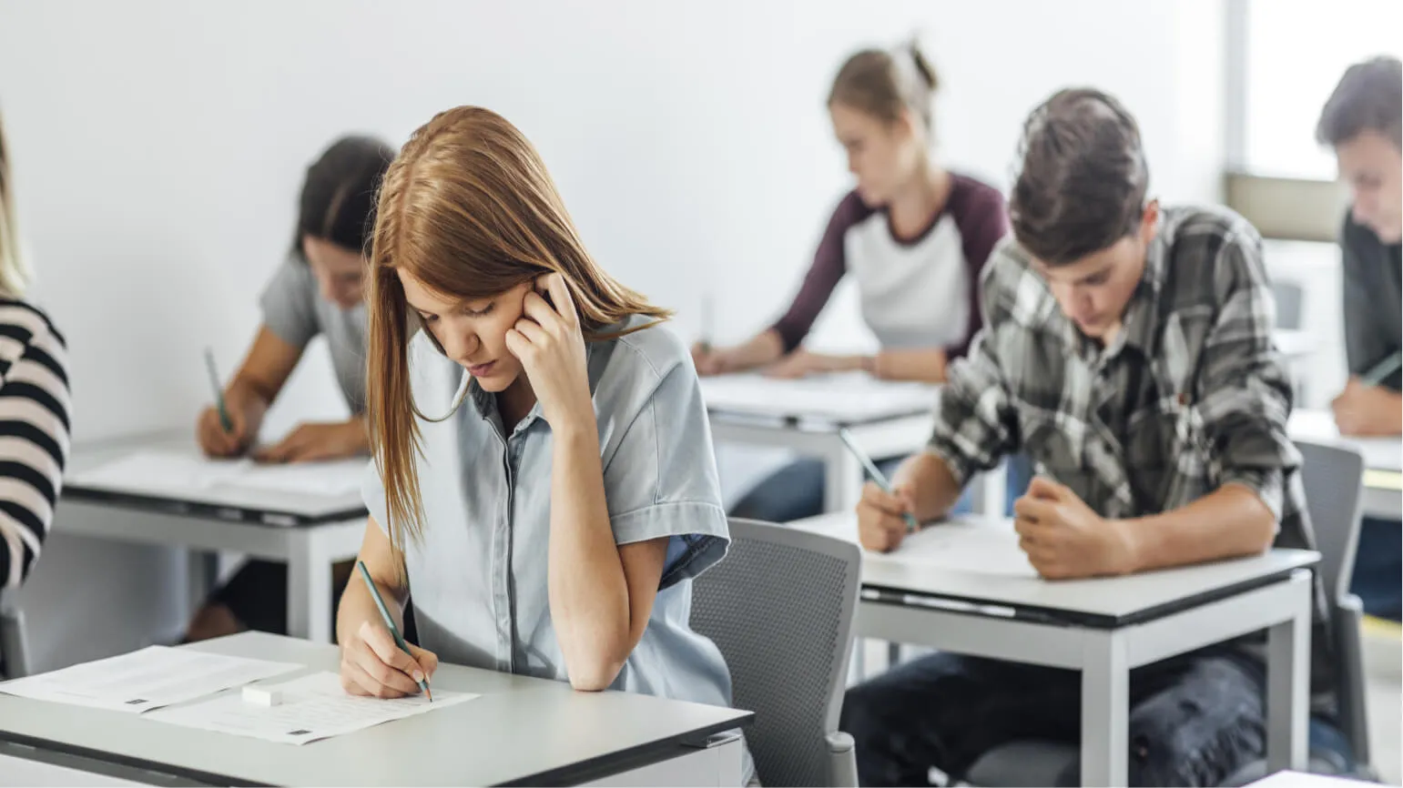 Students in a classroom taking the paper SSAT.
