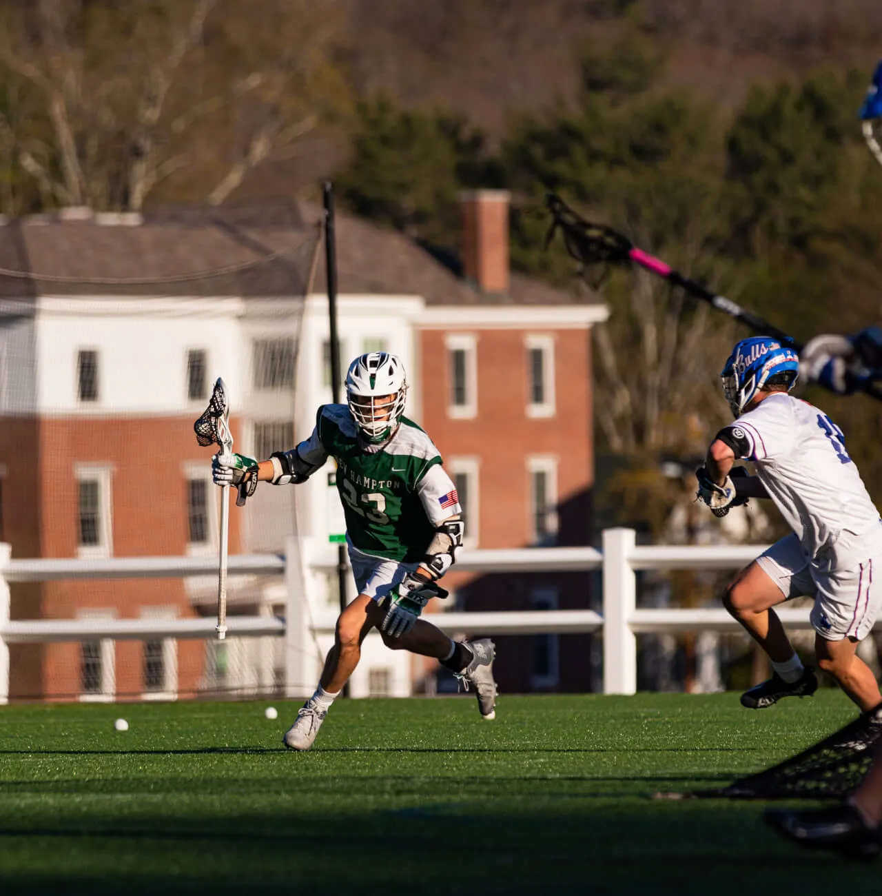 Một cầu thủ lacrosse của trường New Hampton School đang chạy với quả b&oacute;ng trong gậy.