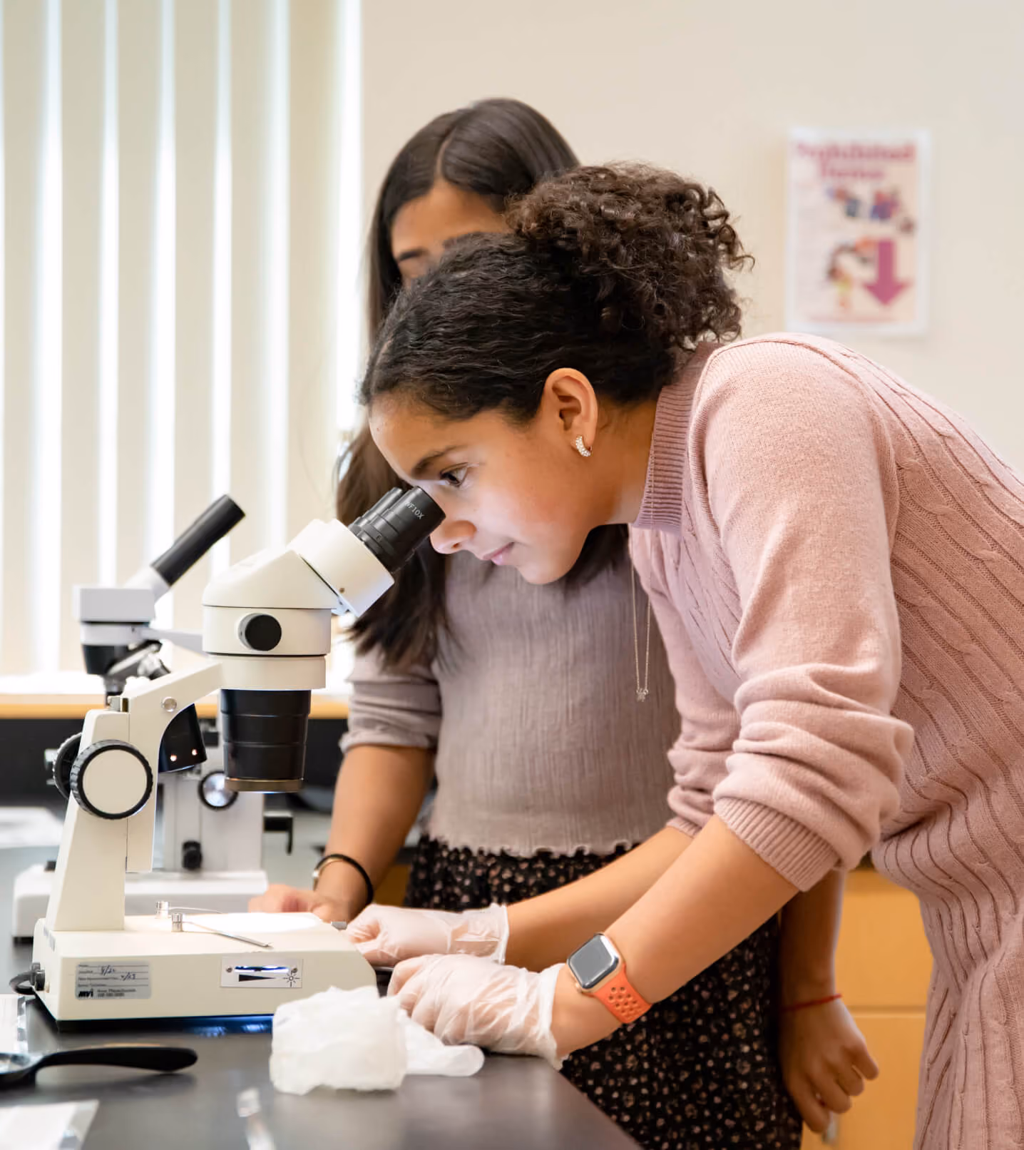 A Fay School student looking through a microscope.