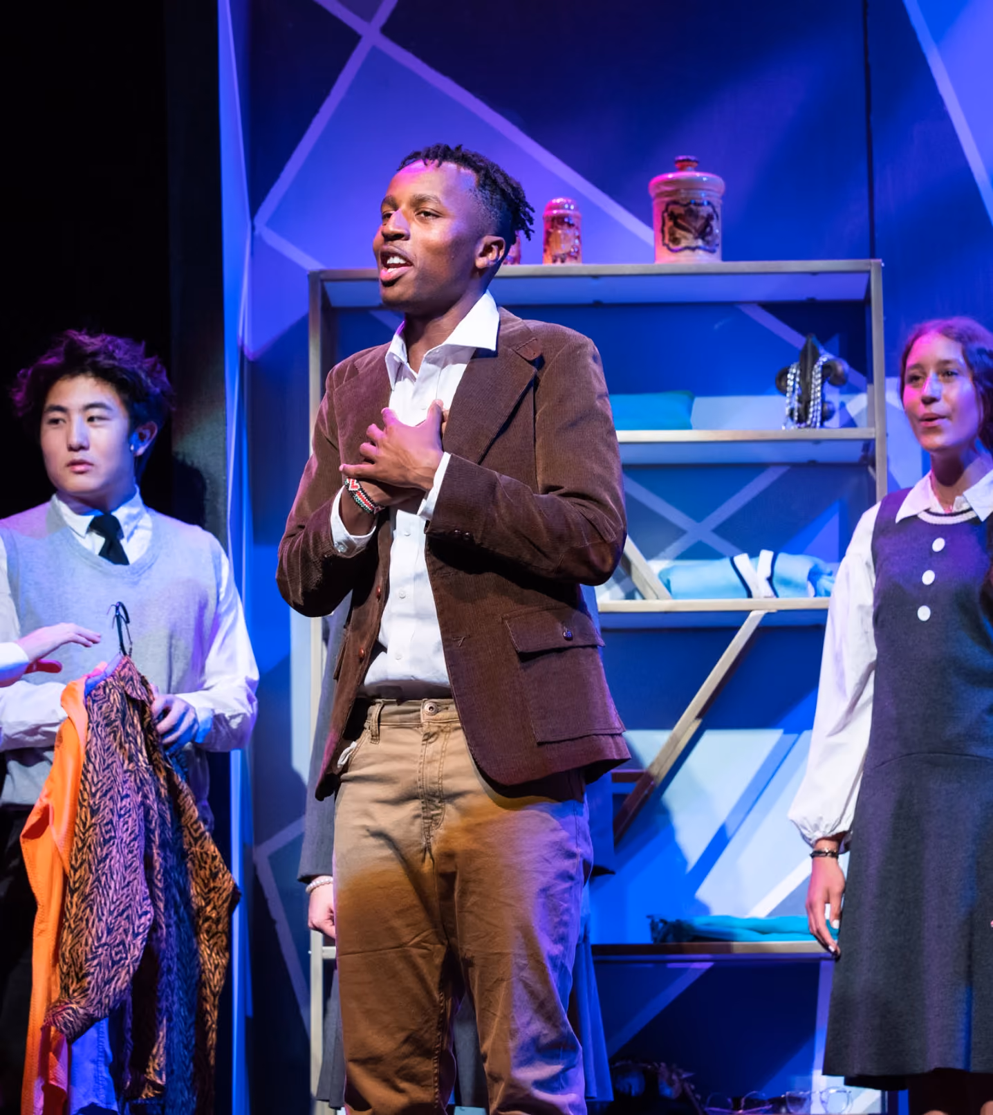 A MIddlesex School student sings on stage.