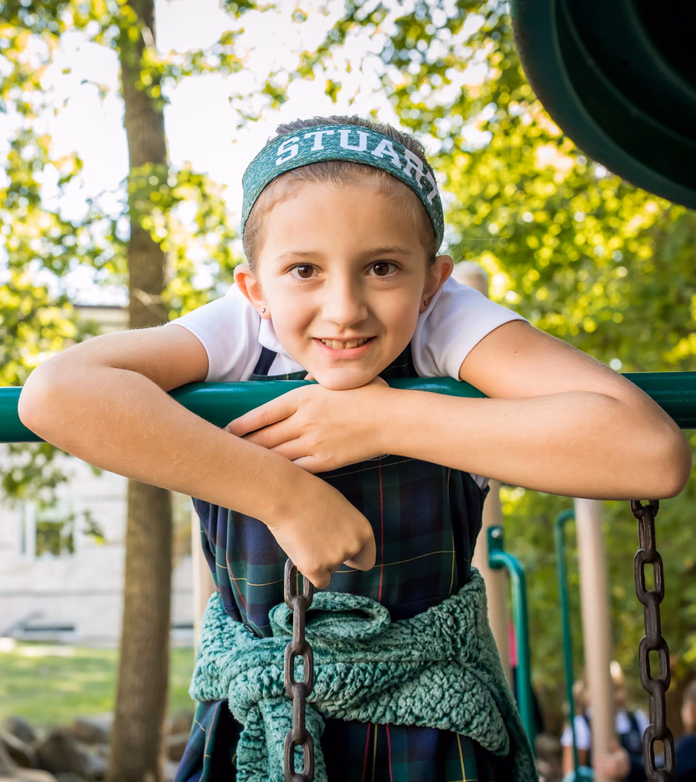 A Stuart Country Day School student hangs over a swing set.