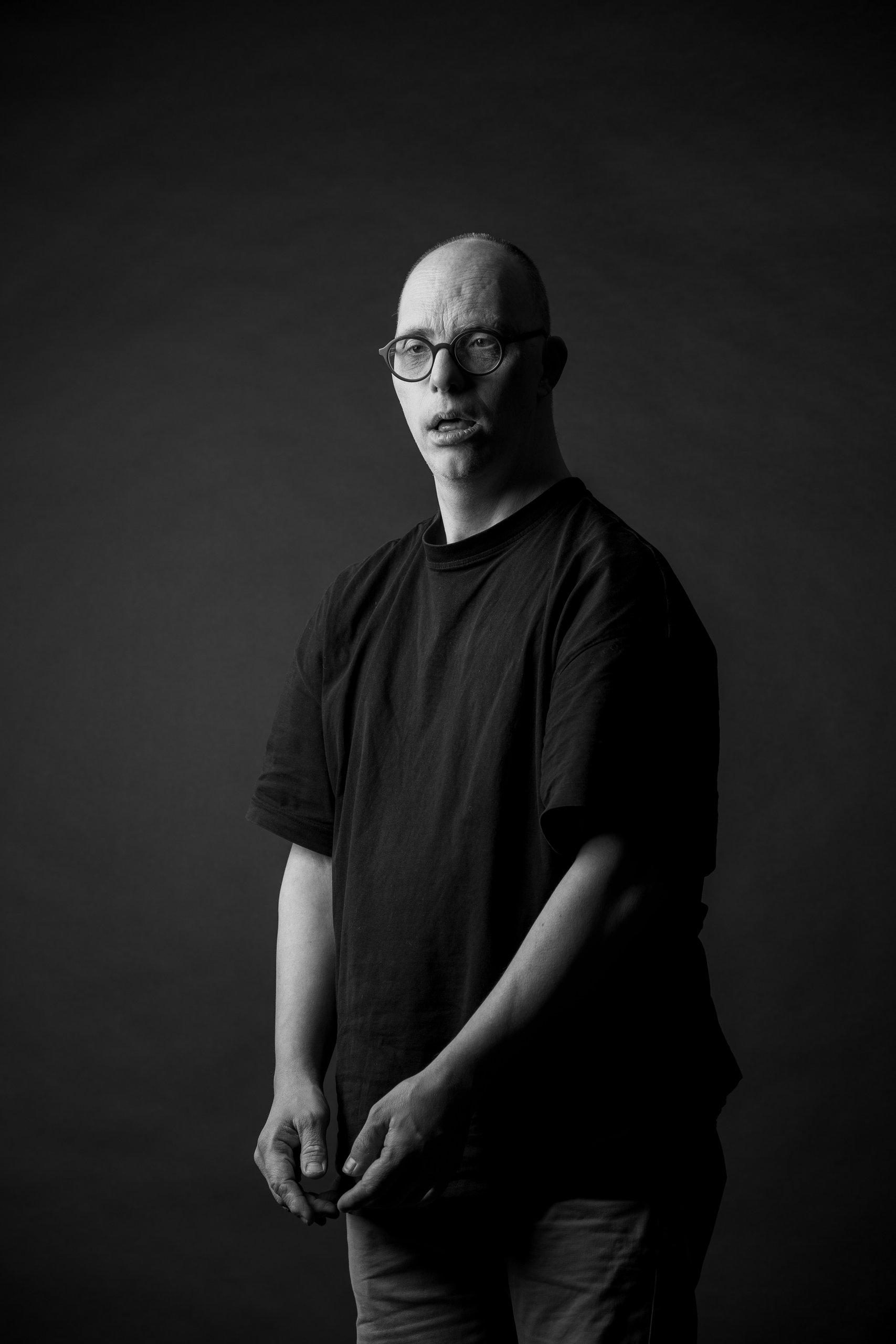 Studio portrait of Willem in a black t-shirt against a dark background