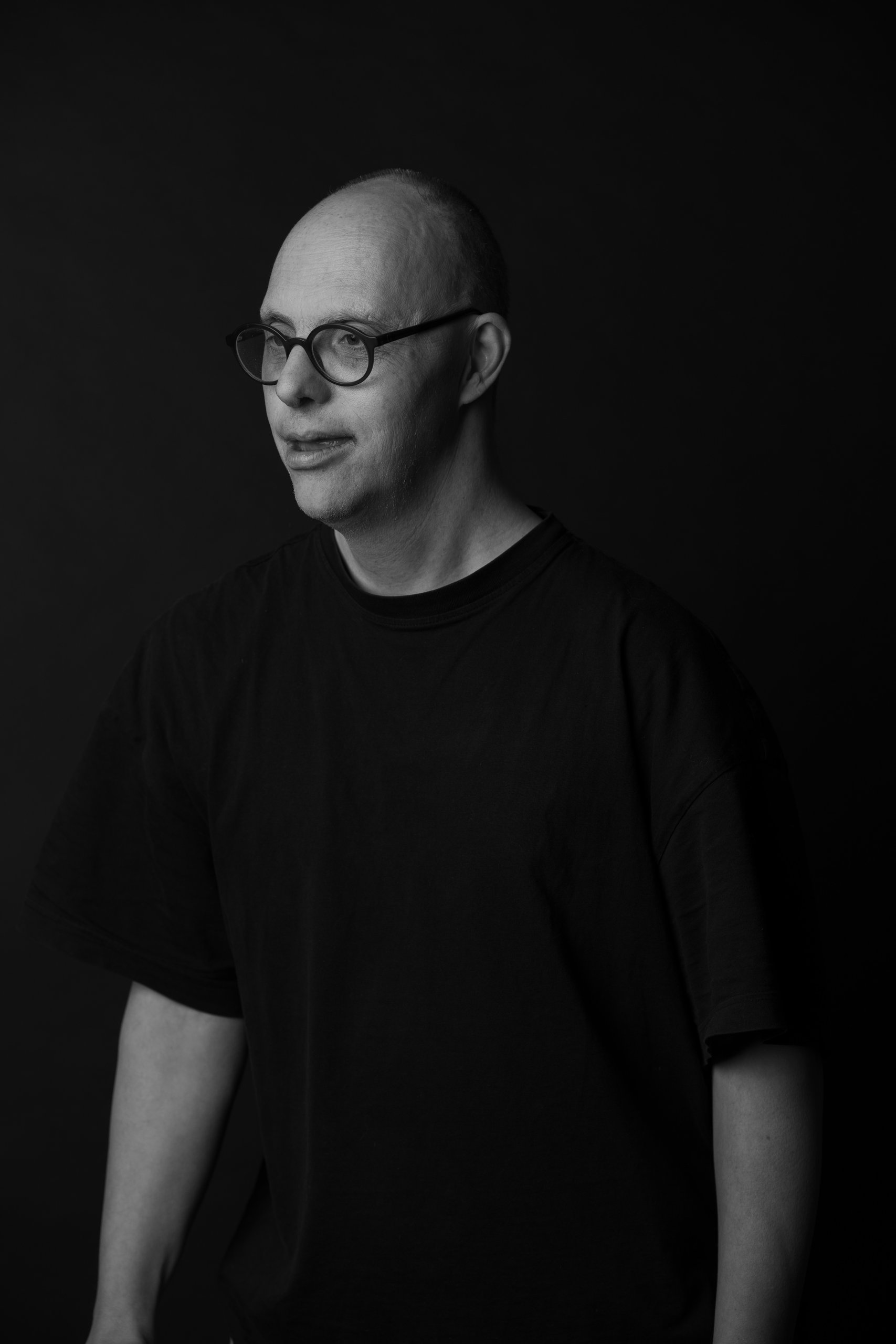 Willem glancing sideways with a gentle smile, black and white studio portrait