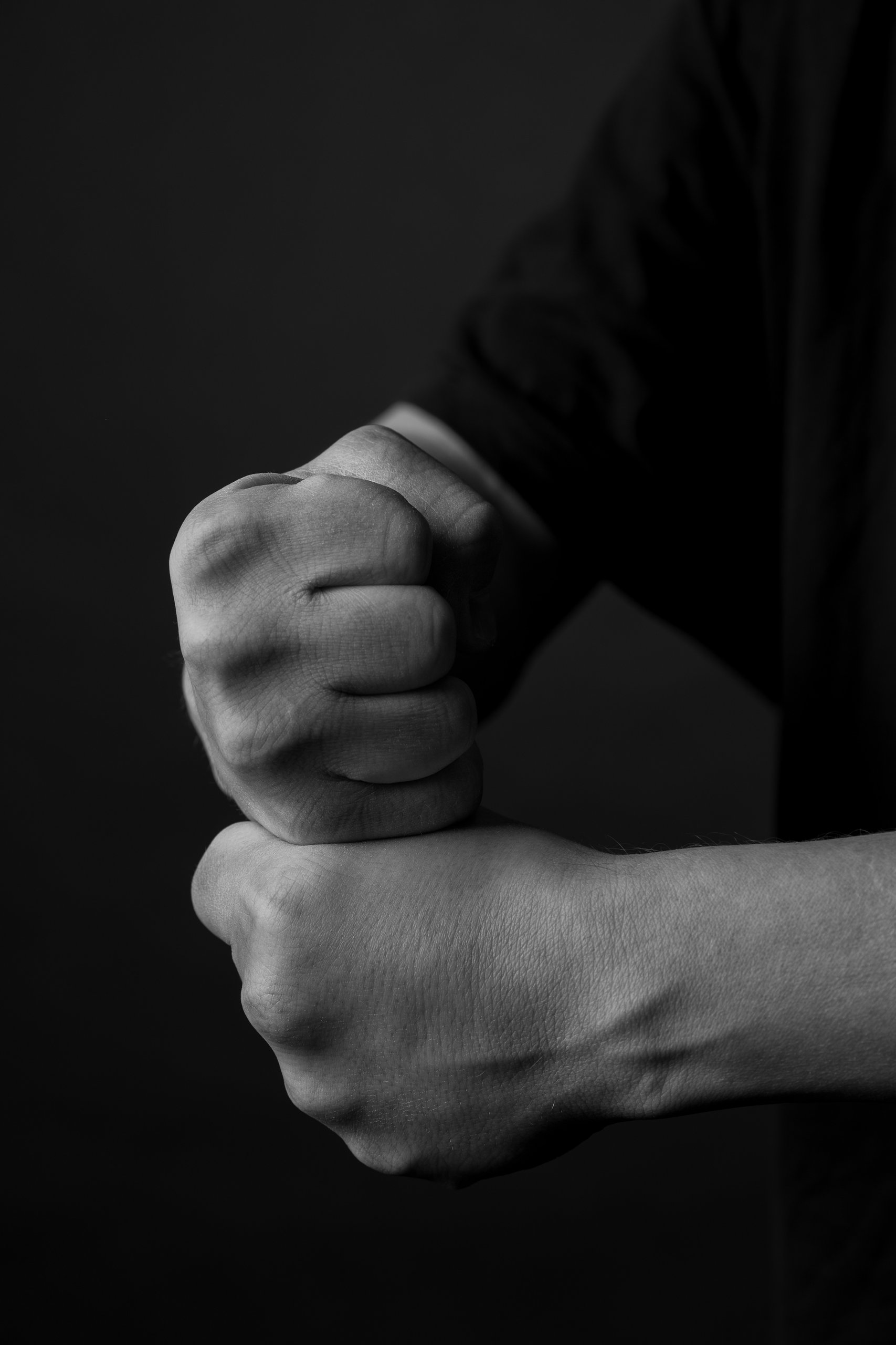 A fist resting on another fist, black and white
