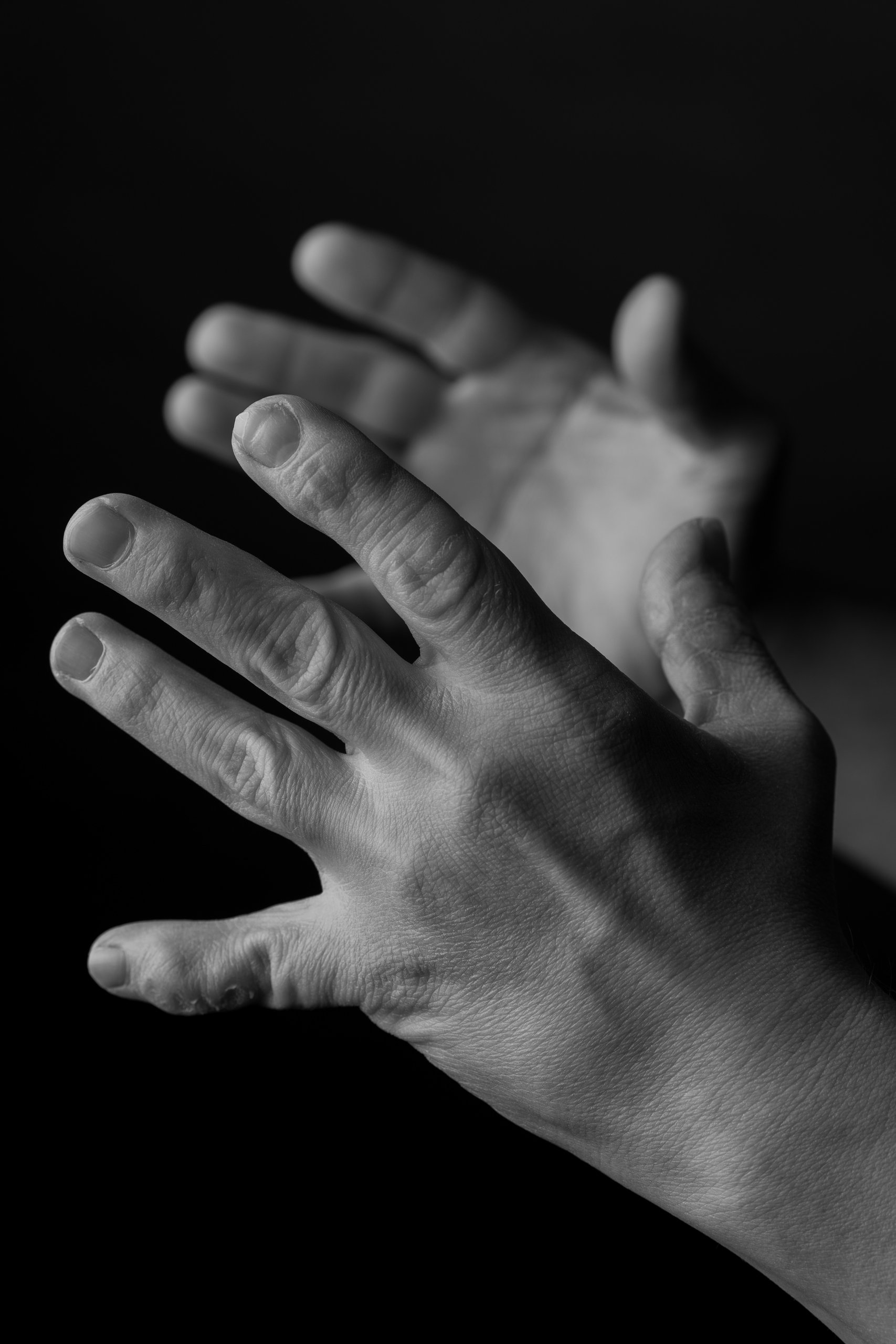 Open reaching hands in dramatic light