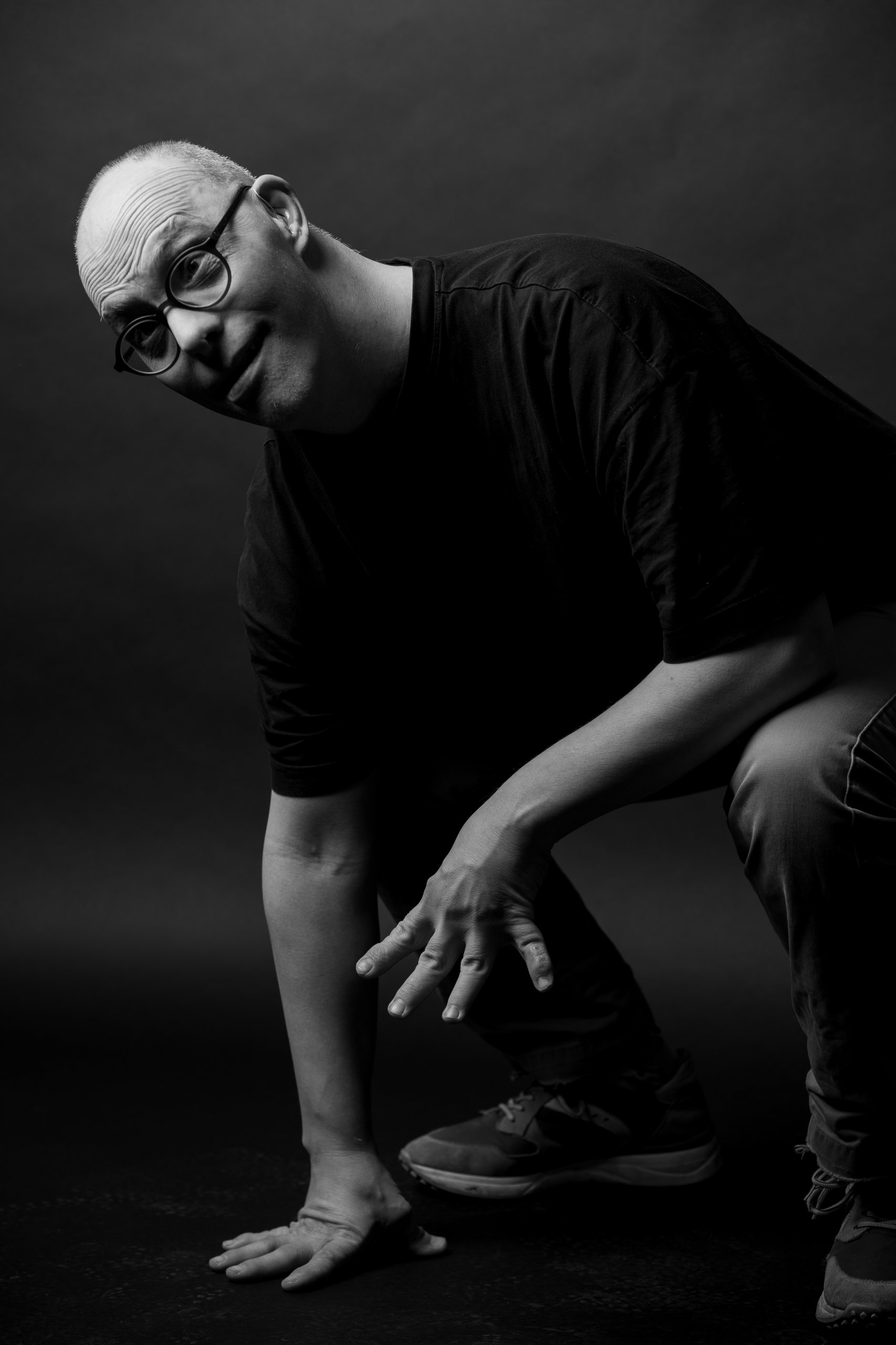 Willem crouching low, looking up at the camera with a grin