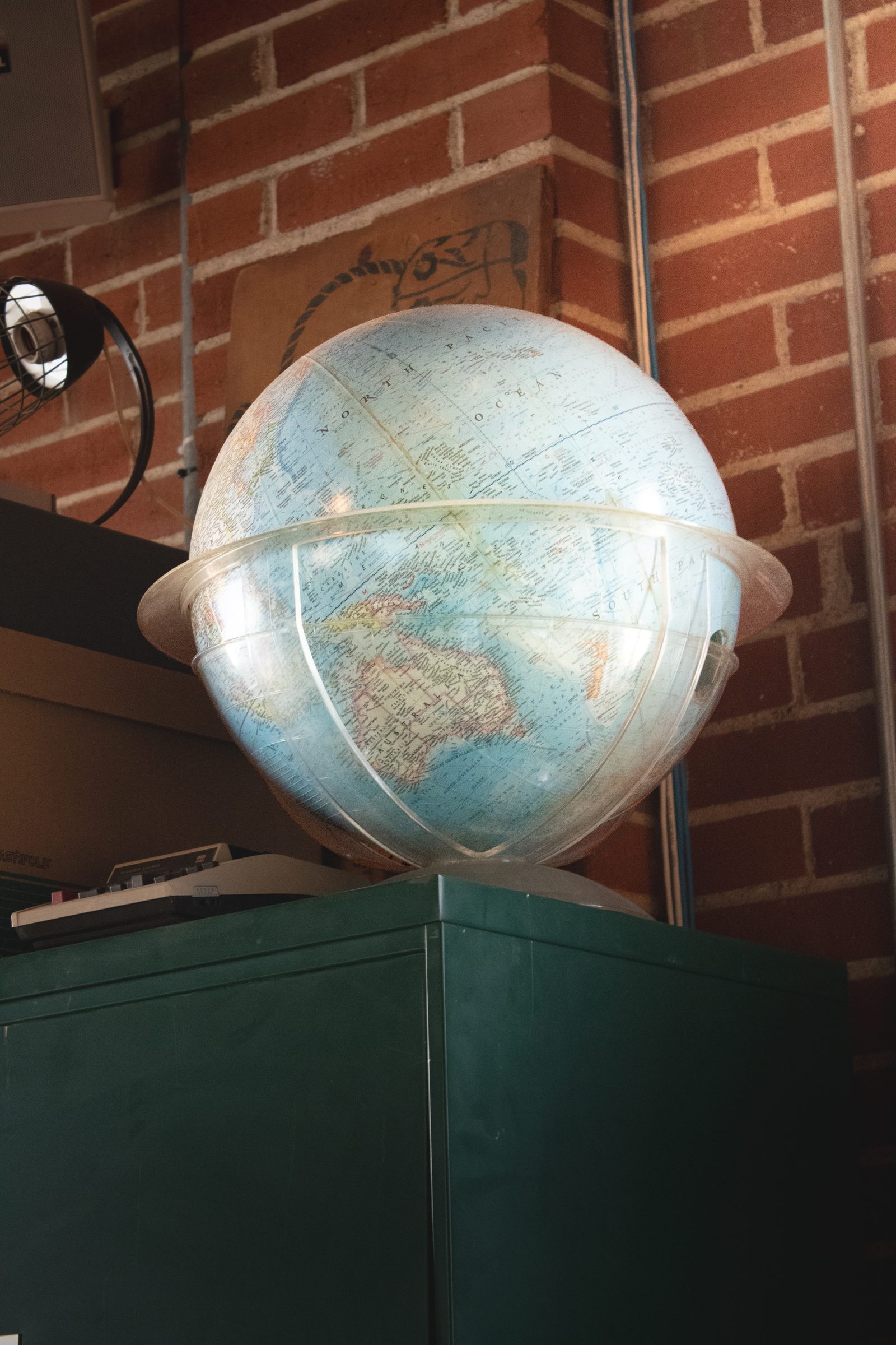 A vintage globe on a green cabinet.