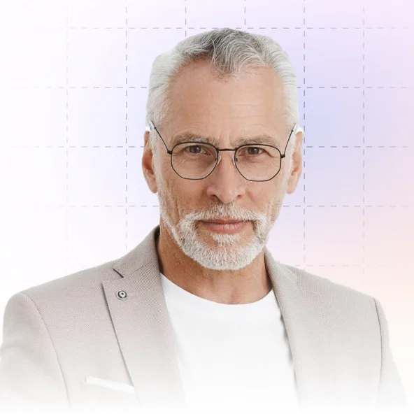 Portrait of a mature man with gray hair and beard wearing glasses and a light beige blazer over a white shirt.