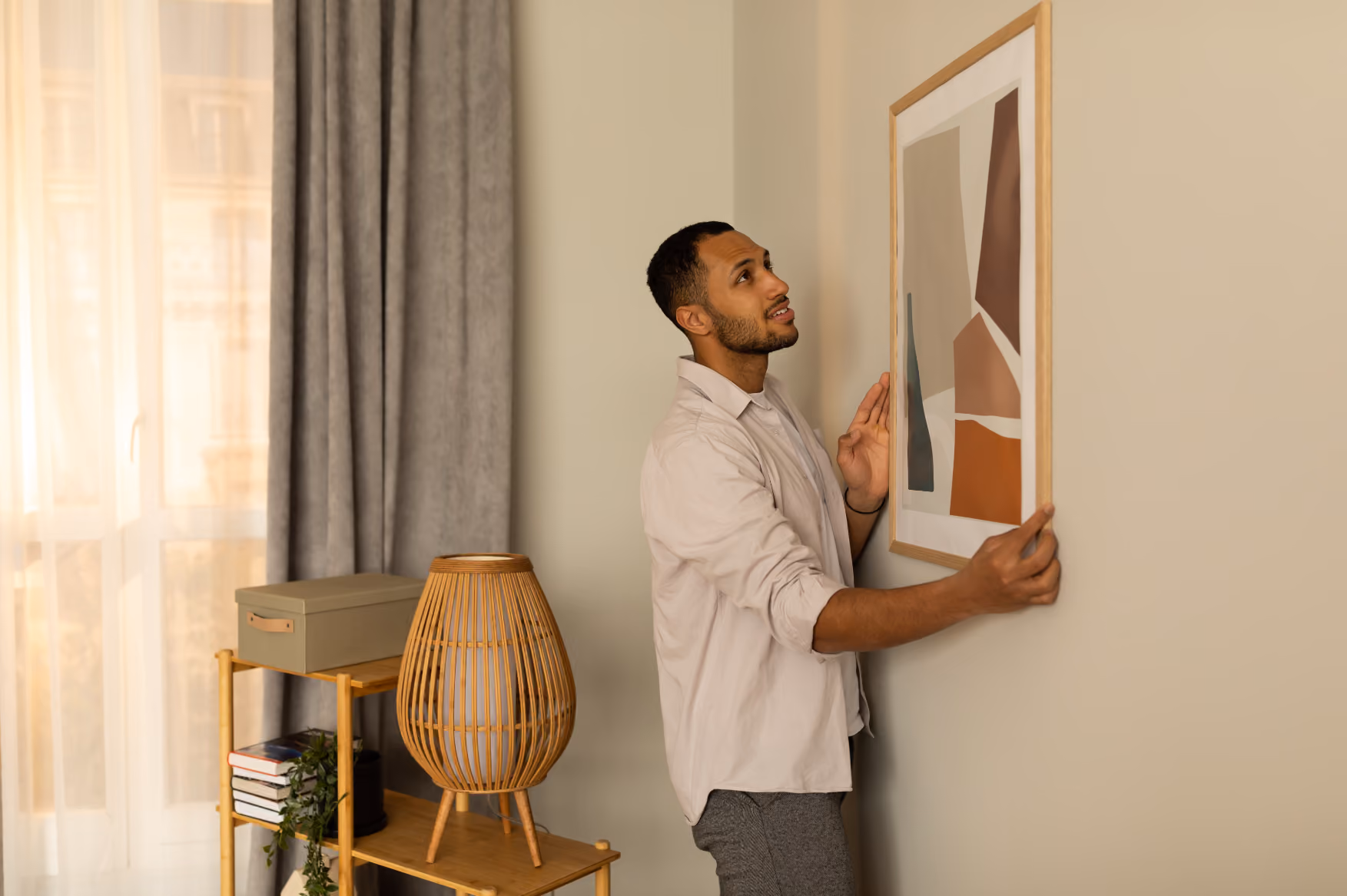 Man hanging picture on wall stock image