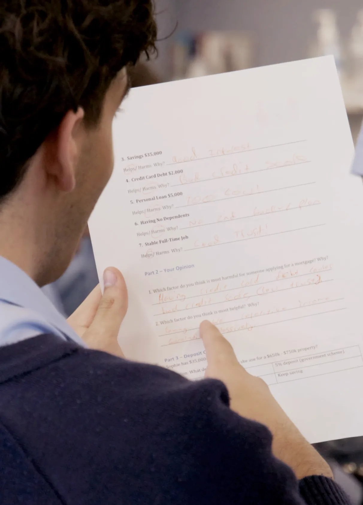 Student reviewing a Financial Literacy Education worksheet covering savings, credit and deposit planning
