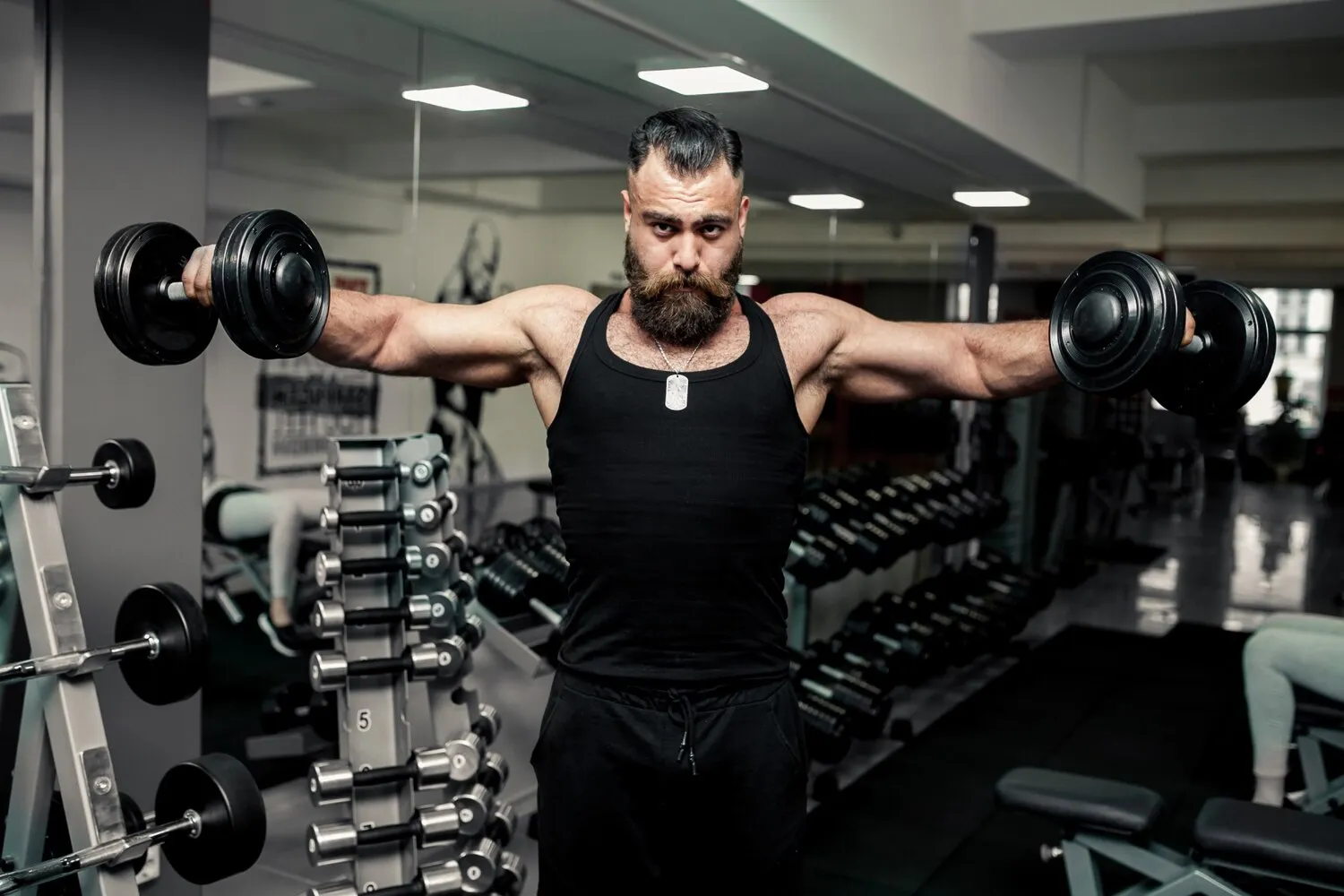Muscular man lifting a dumbbell, showing defined chest, arm, and abdominal muscles.