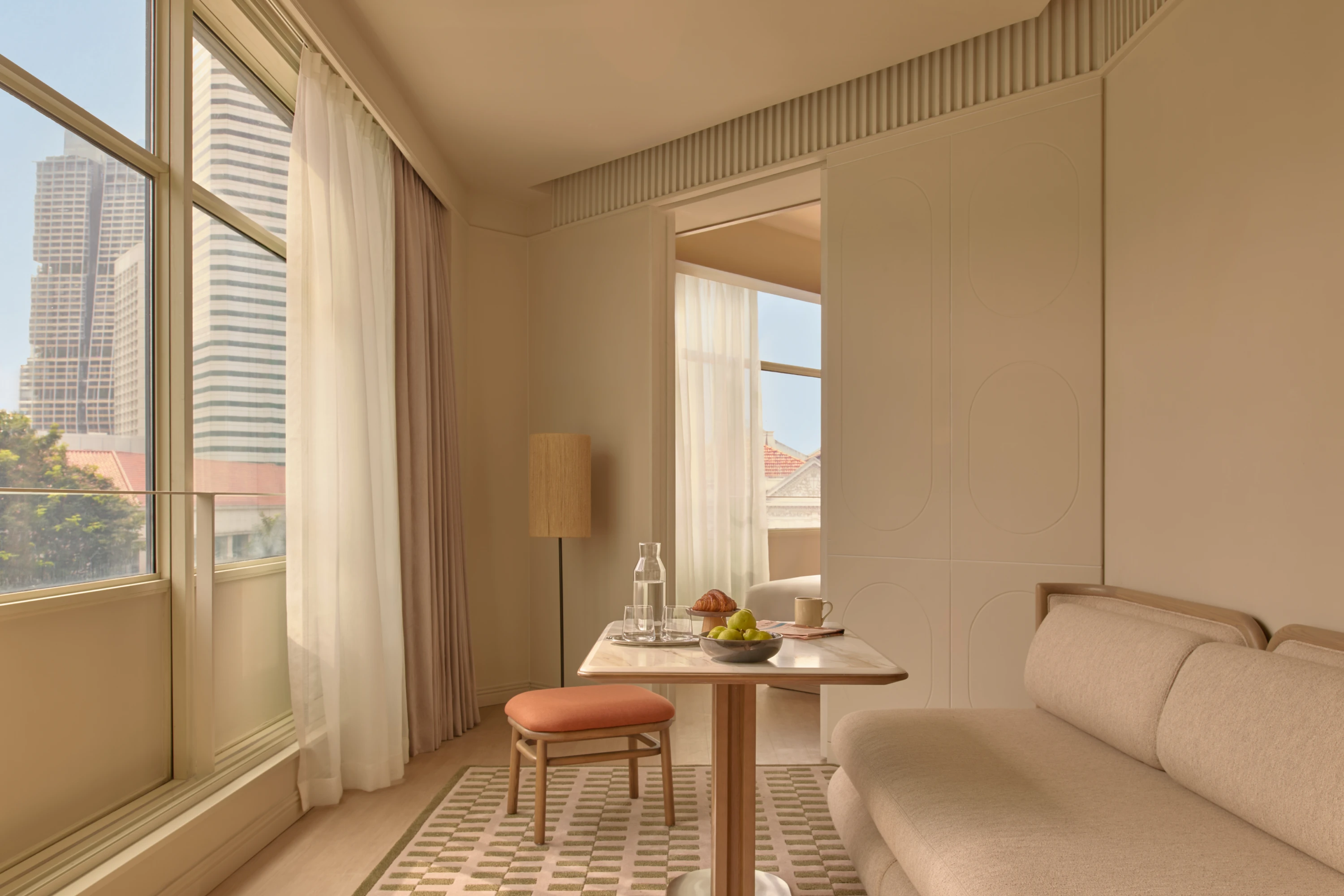 The Civic Suite dining nook with a marble table set for breakfast, the Singapore skyline filling the floor-to-ceiling windows to the left.