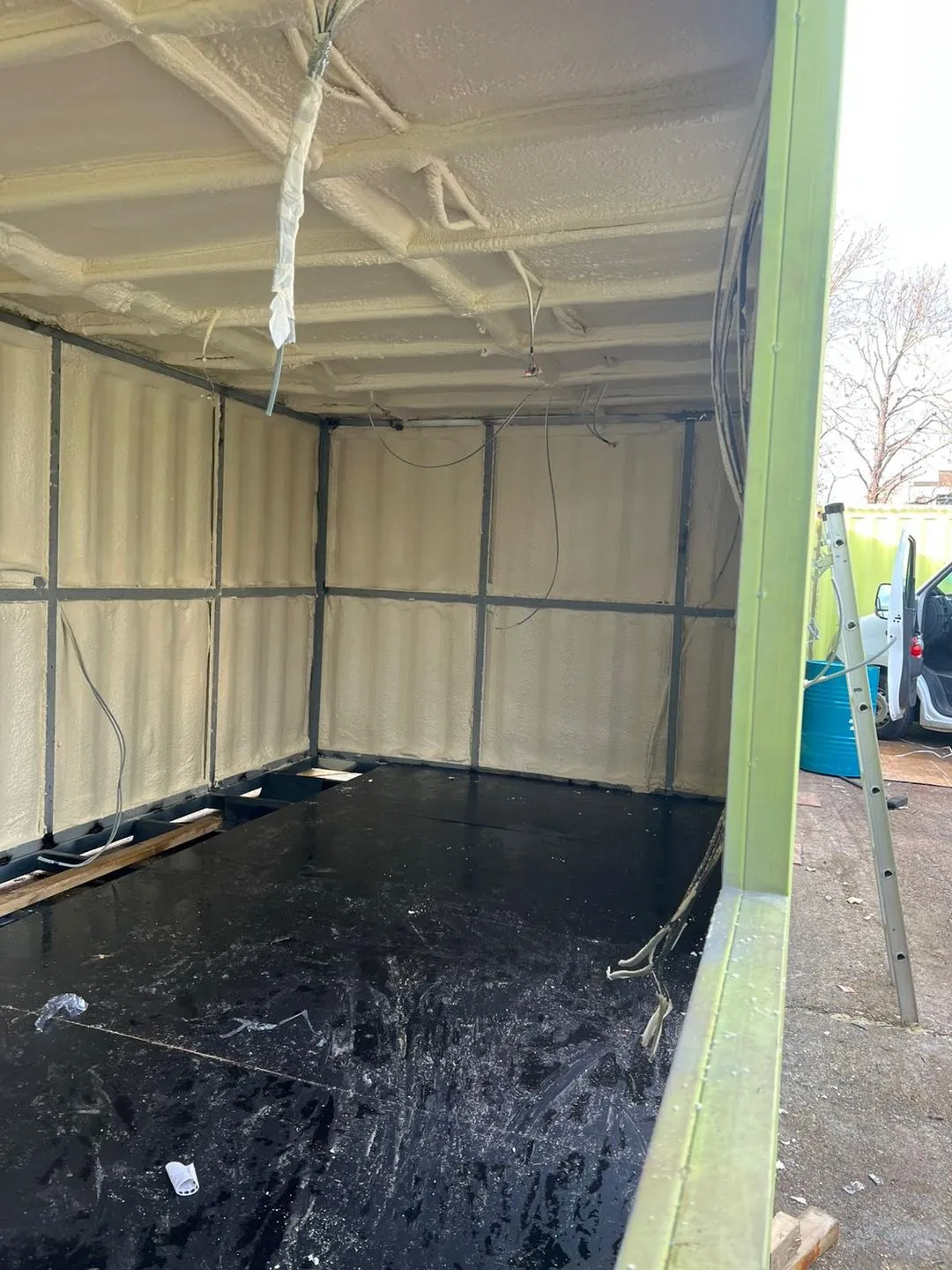 A container ceiling sealed with closed-cell foam, the roof corrugation and end wall in one layer.