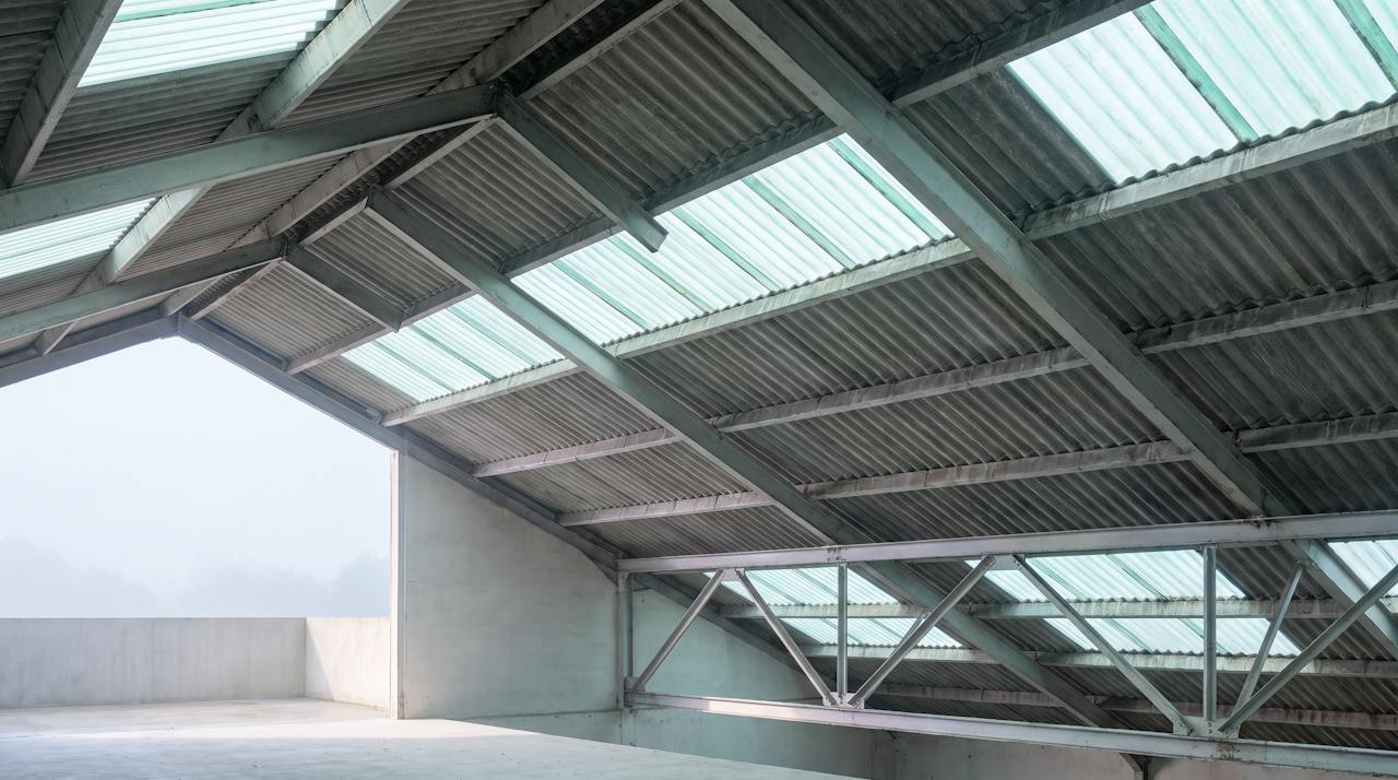 The underside of a corrugated fibre-cement industrial roof seen from below.