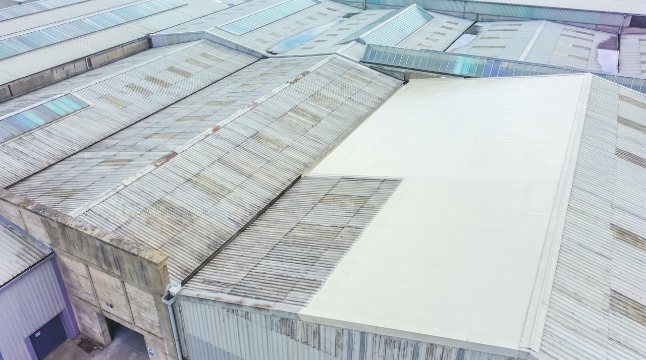 A pale silicone-coated commercial roof seen from above.
