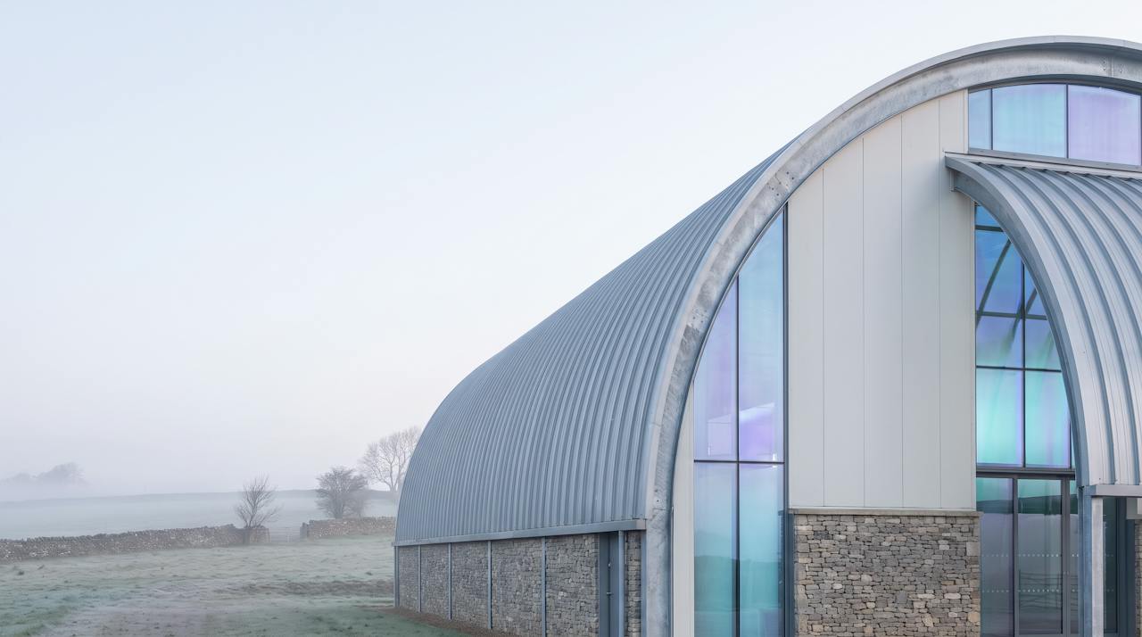 A large arched Quonset-style steel building with its end doors open.