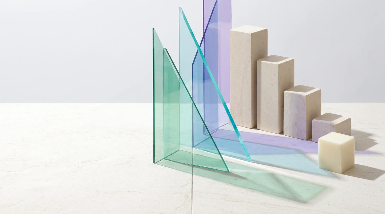 Translucent glass planes cut at sharp angles cast sea-glass and violet light across pale stone, an abstract HOLVEM composition.
