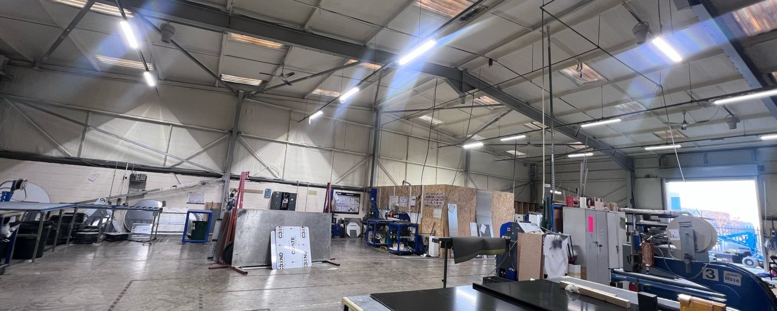 Inside the Nuneaton Signs factory after the work: roof panels and purlins under a continuous cream closed-cell layer.