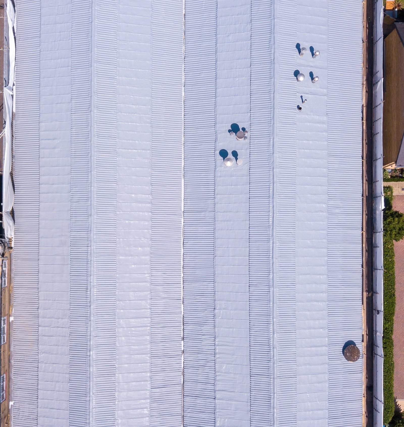 After, from above: the four pitched bays and the valley gutter under one continuous coated surface.