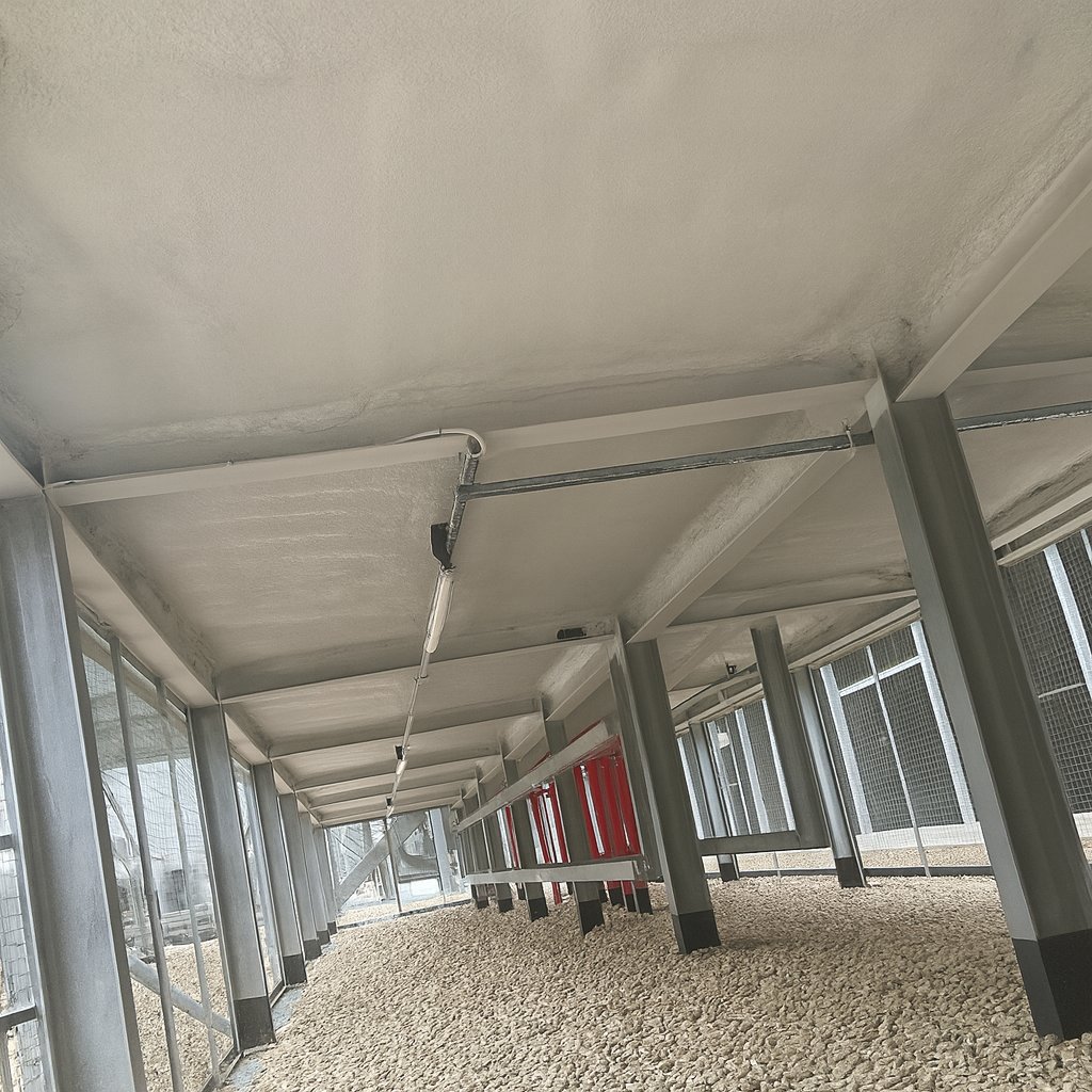During: the application advancing across the soffit, beams and column heads wrapped as the layer grows.
