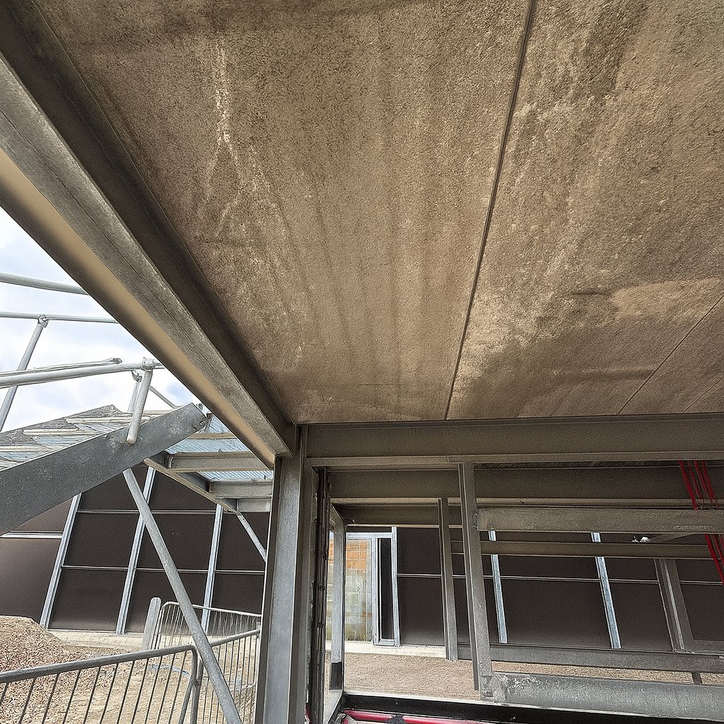 Before: the exposed concrete soffit of the substation undercroft, downstand beams and column heads bare.