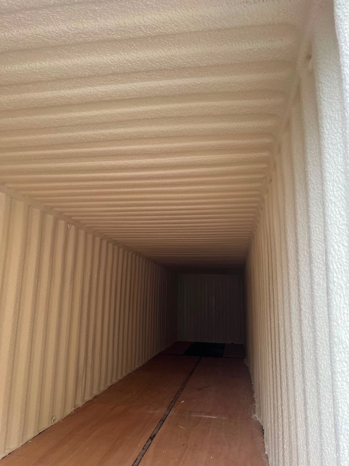 After: the full-length interior of the container, walls, ceiling and end in one continuous cream layer.