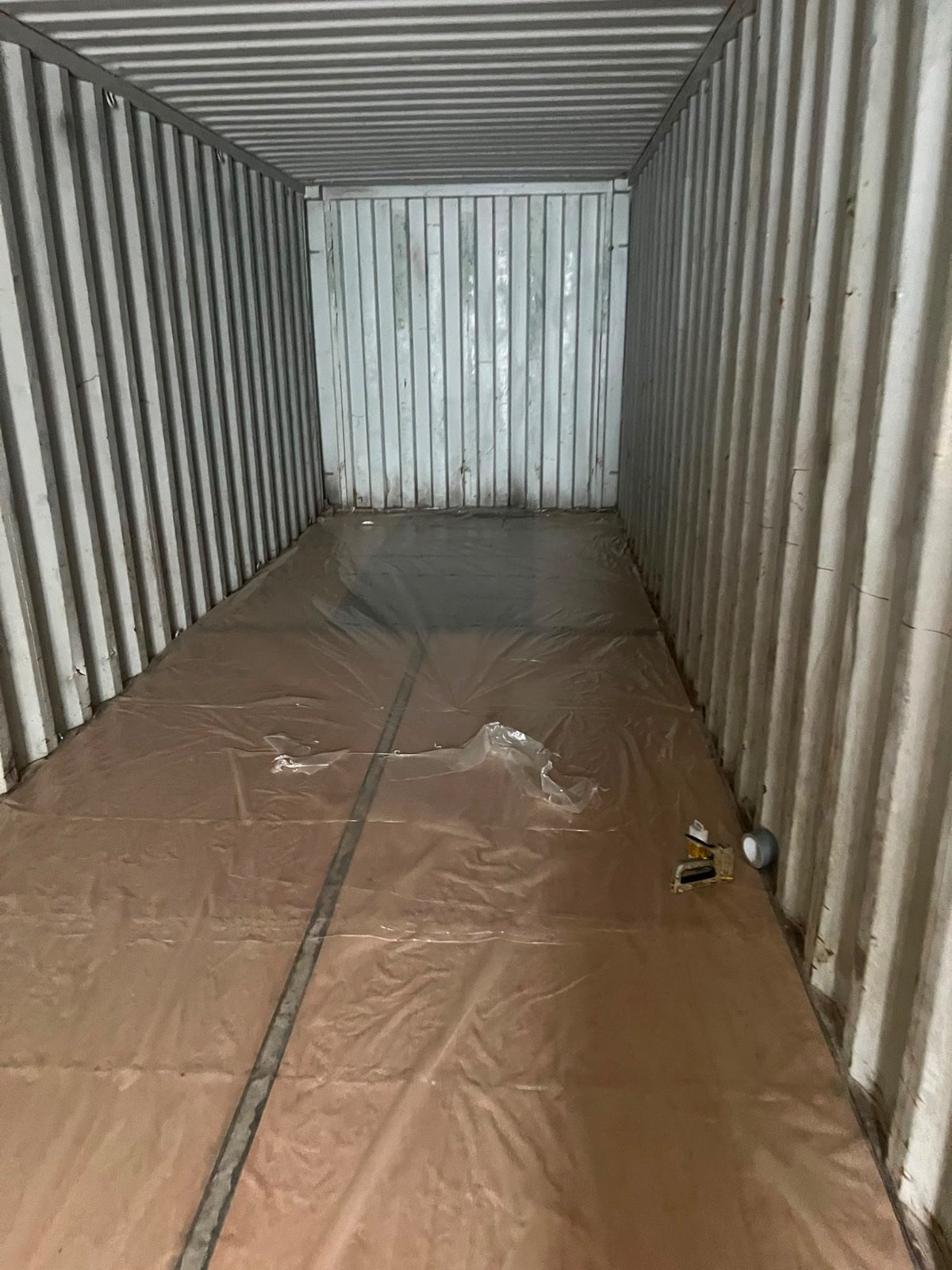 Preparation: the container emptied and sheeted, the floor protected before spraying.