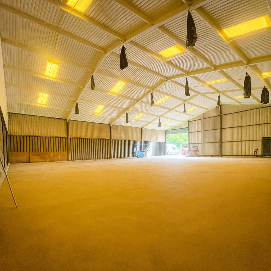 During: closed-cell foam being sprayed to the roof underside from a scissor lift, polythene over the equipment below.