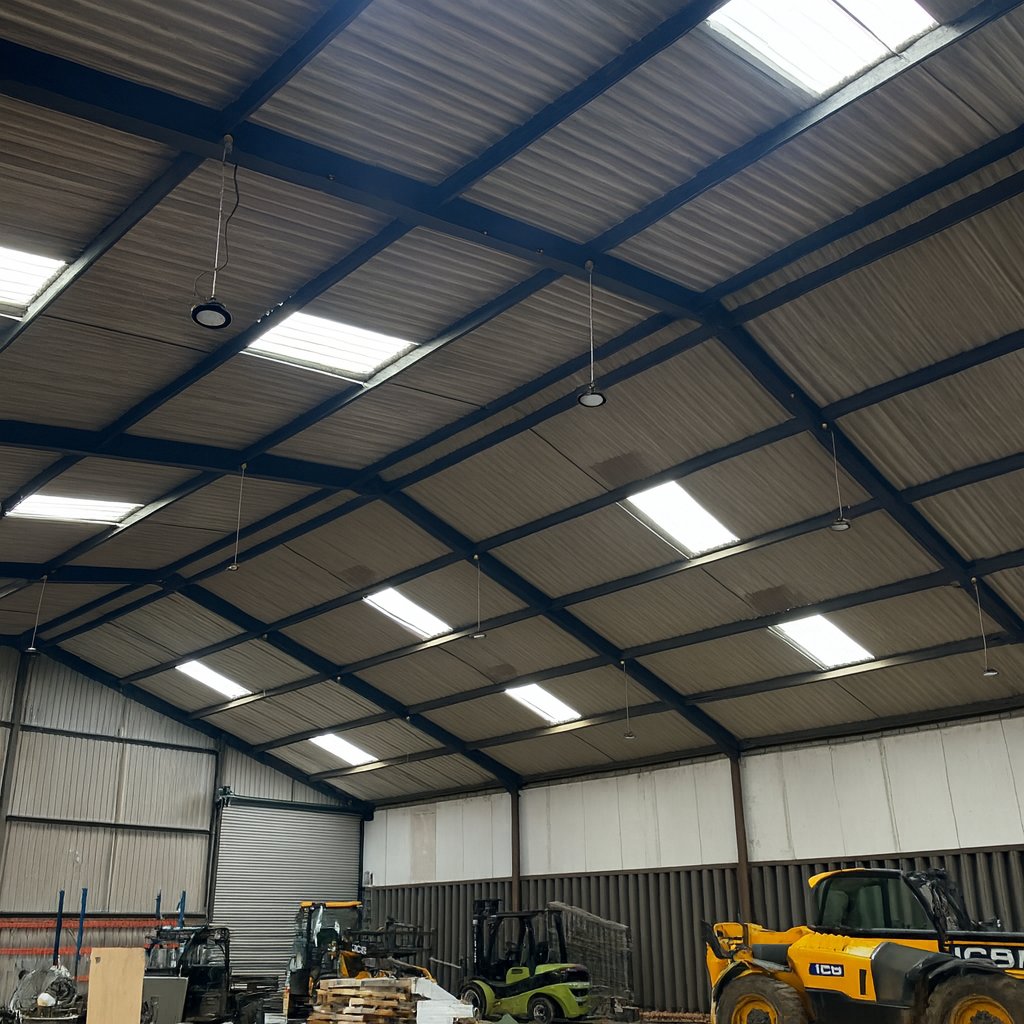 Before: the unit interior with vehicles and equipment beneath the uninsulated roof.