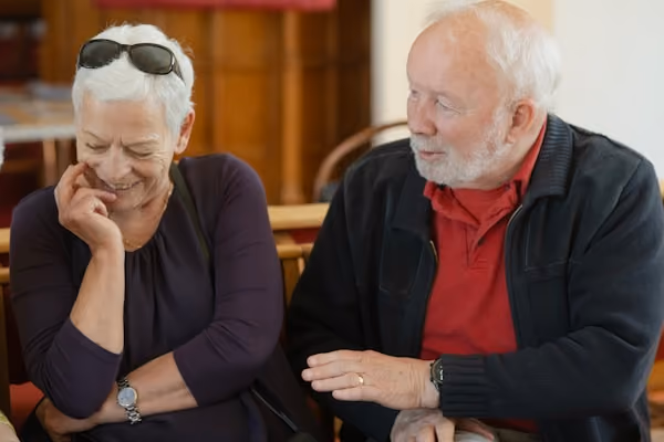 An older couple is talking and smiling.