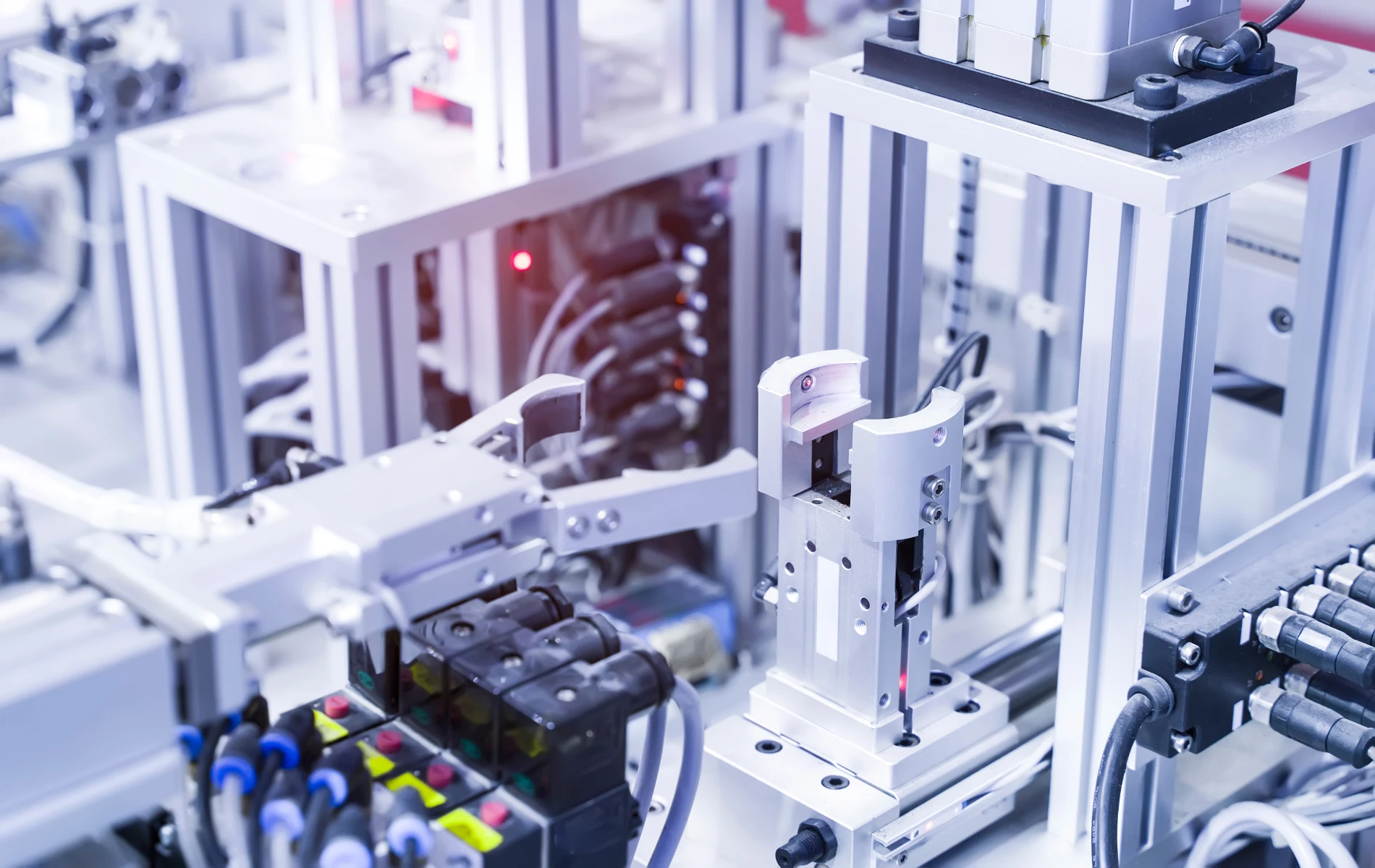Industriemaschine mit Metallarmen, Kabeln und Sensoren in einem Produktionsprozess.