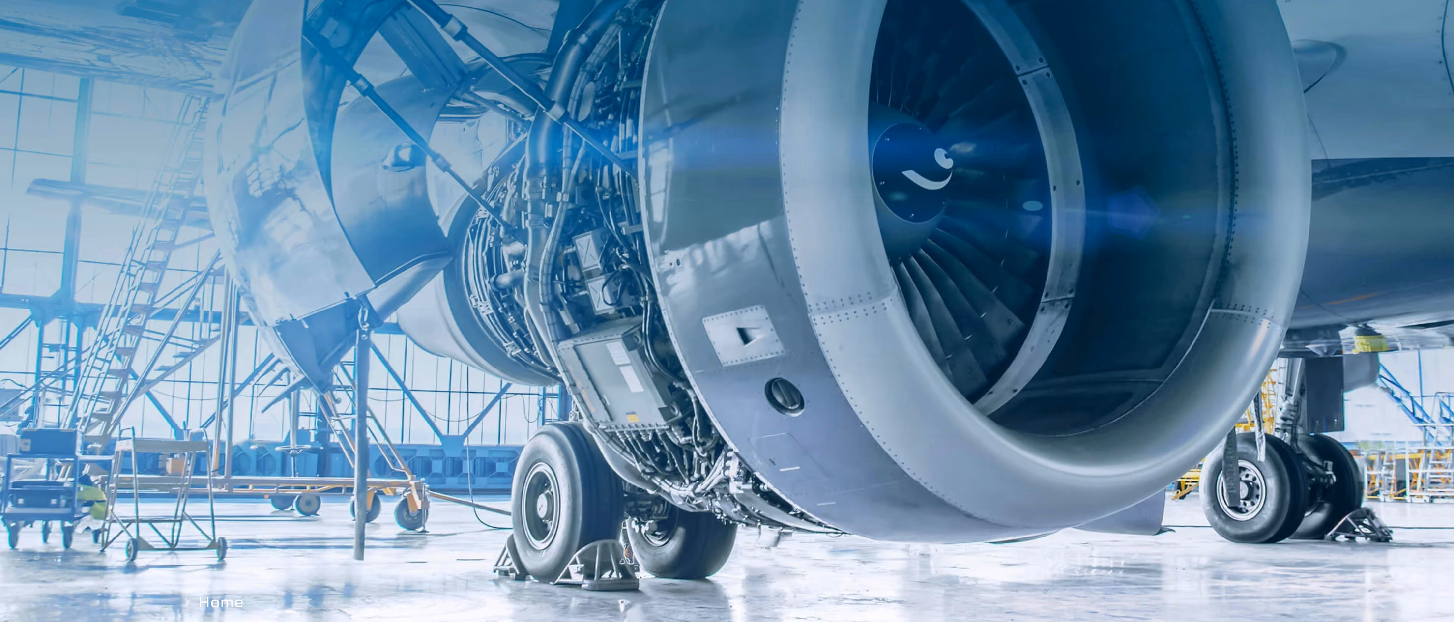 Nahaufnahme eines Flugzeugtriebwerks im Hangar mit offenem Gehäuse und sichtbaren mechanischen Teilen.