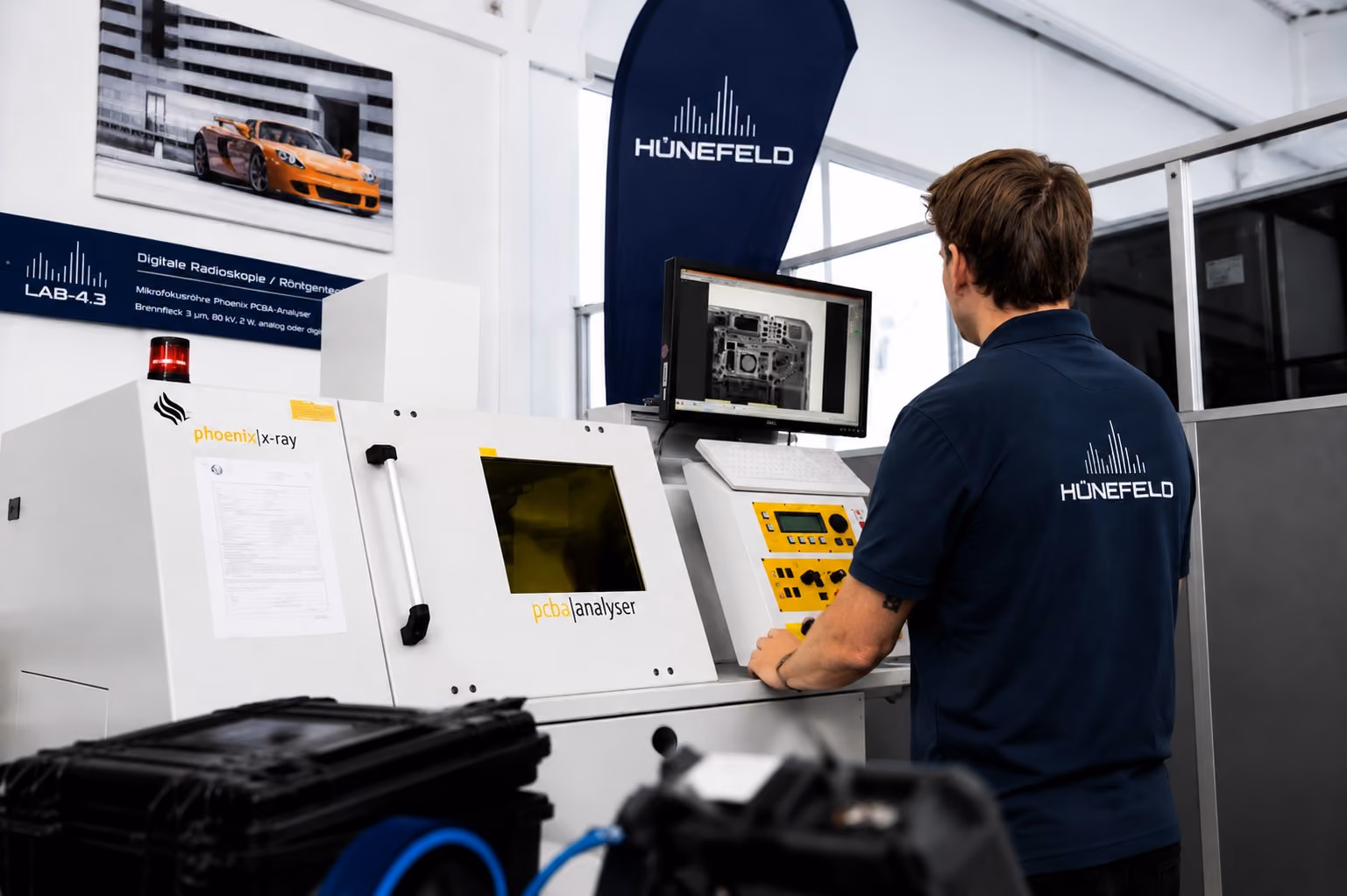 Techniker bedient Phoenix X-ray PCBA-Analyser mit Leiterplatten-Röntgenbild am Monitor.