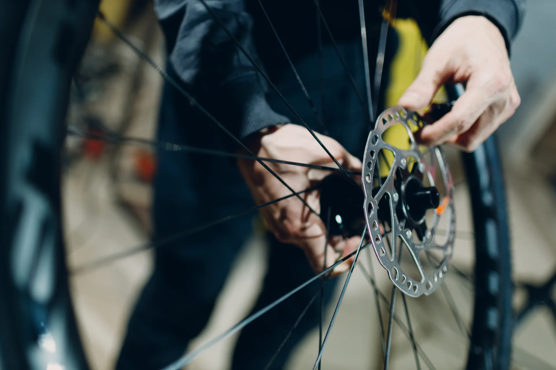 Person montiert oder repariert die Scheibenbremse an einem Fahrrad-Vorderrad.