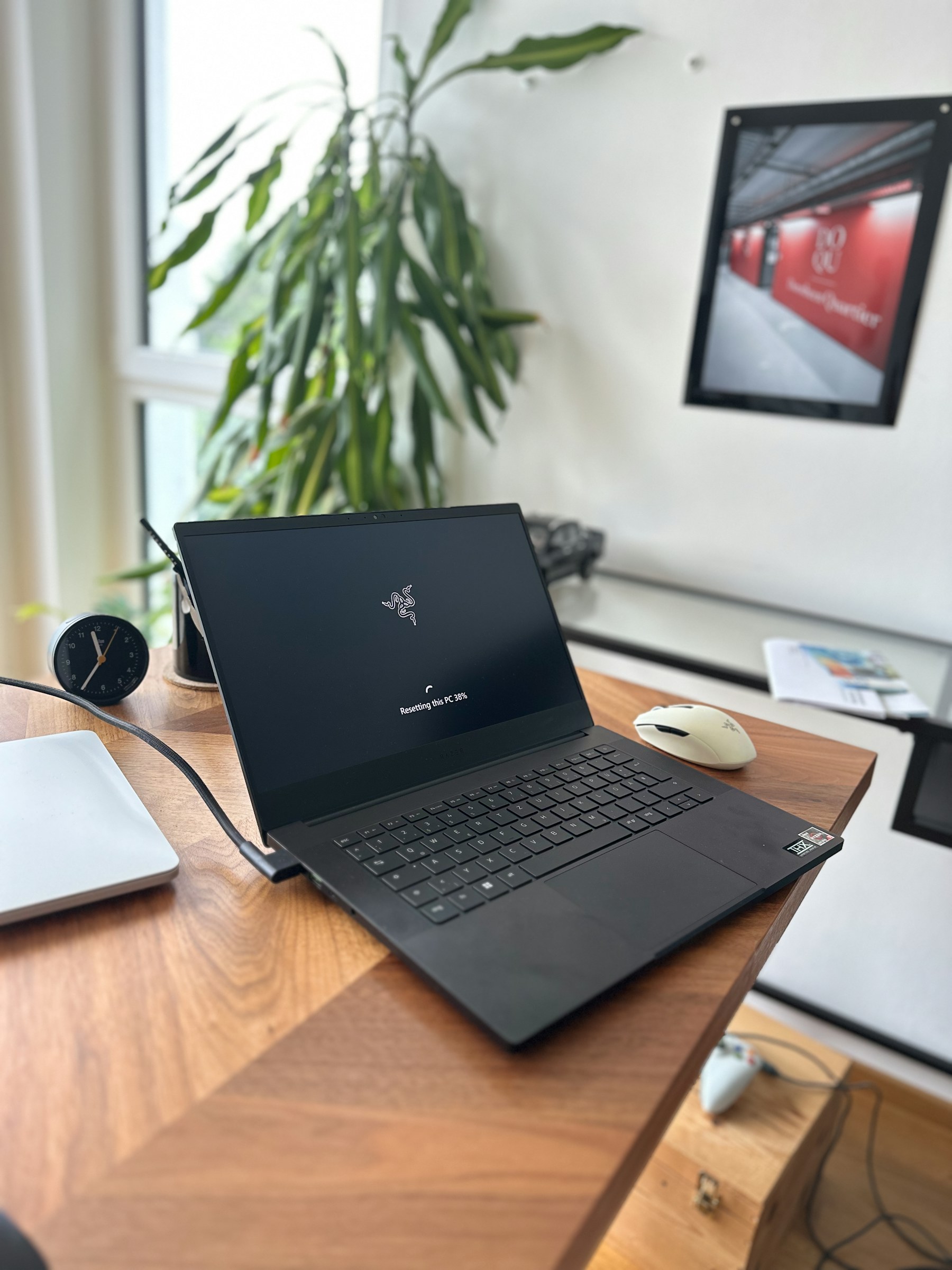 Multi-Region-Recovery für einen SaaS-Anbieter – Öffne einen schwarzen Laptop auf einem Holztisch mit Pflanze