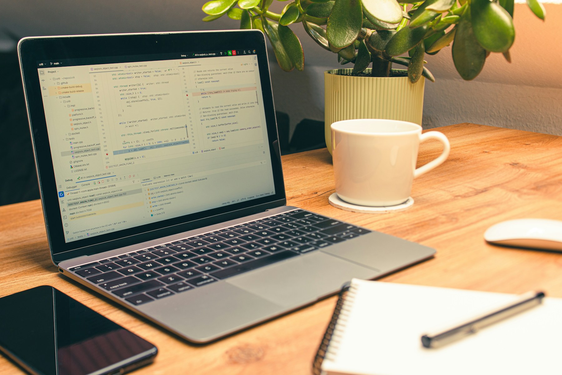 BCM für einen europäischen Cloud-Service-Provider – Laptop mit Code auf dem Bildschirm, Kaffeetasse und Pflanze