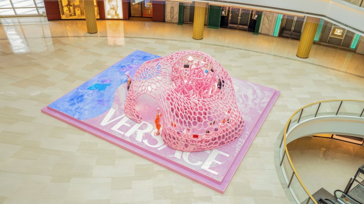 Luftaufnahme der pinken Korallen-Installation von Versace mit Schriftzug „Versace“ im Einkaufszentrum