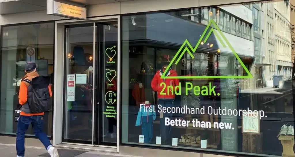 Ladenfront des Secondhand-Outdoorshops 2nd Peak in Zürich mit grünem Berg-Logo und dem Slogan „Better than new“