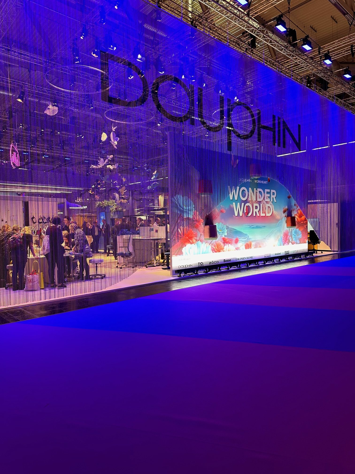 Blau beleuchteter Dauphin-Messestand „Wonder World“ auf der Orgatec 2024 mit Besuchern