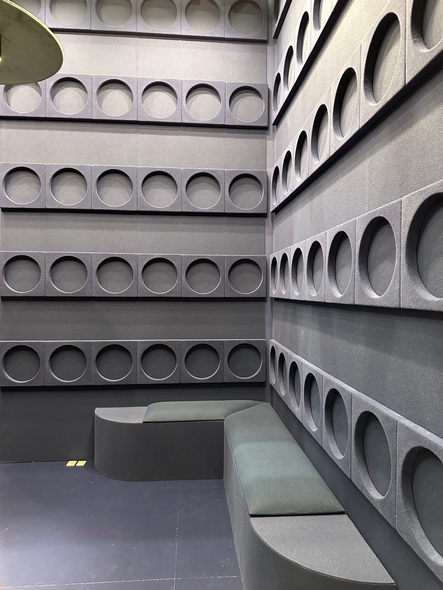 Akustikwand mit runden Vertiefungen in Grautönen, Messestand auf der Orgatec 2024
