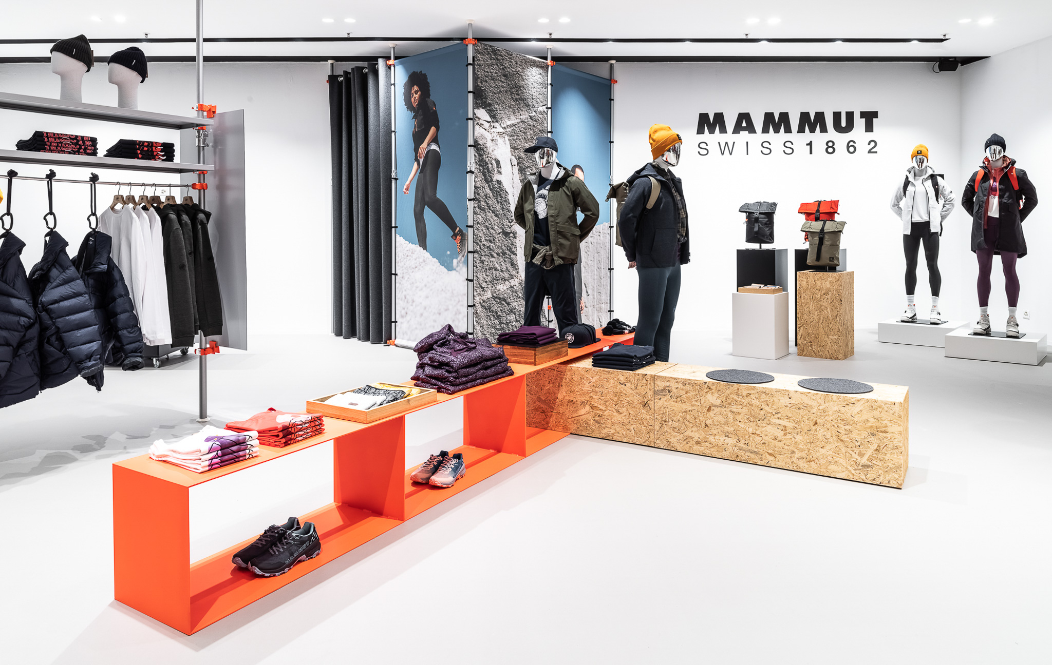 Mammut pop-up store at Jelmoli Zurich: orange shelving with outdoor apparel and backpacks