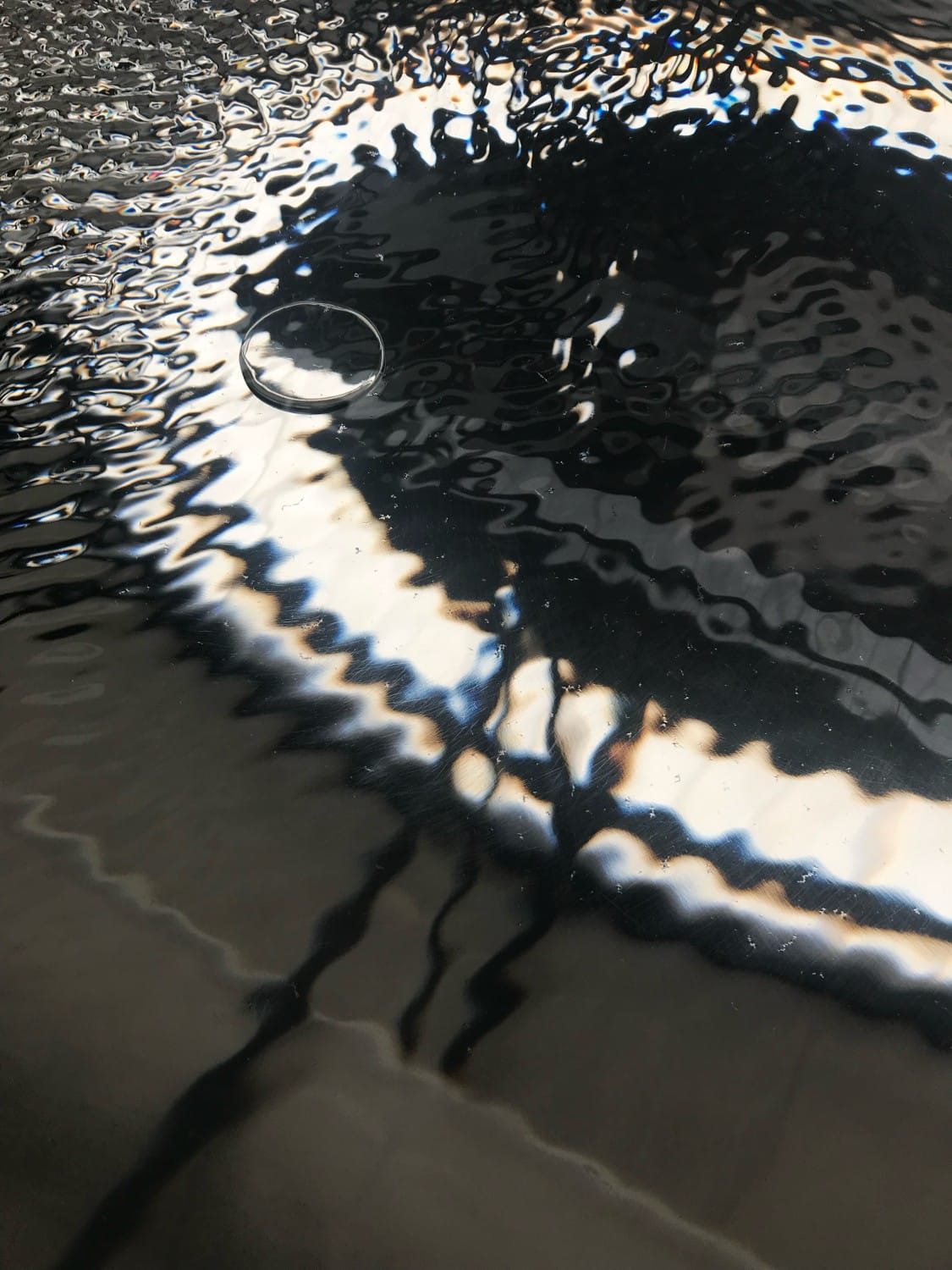 Abstract water surface with ripples and reflected light, water-themed installation at the design week