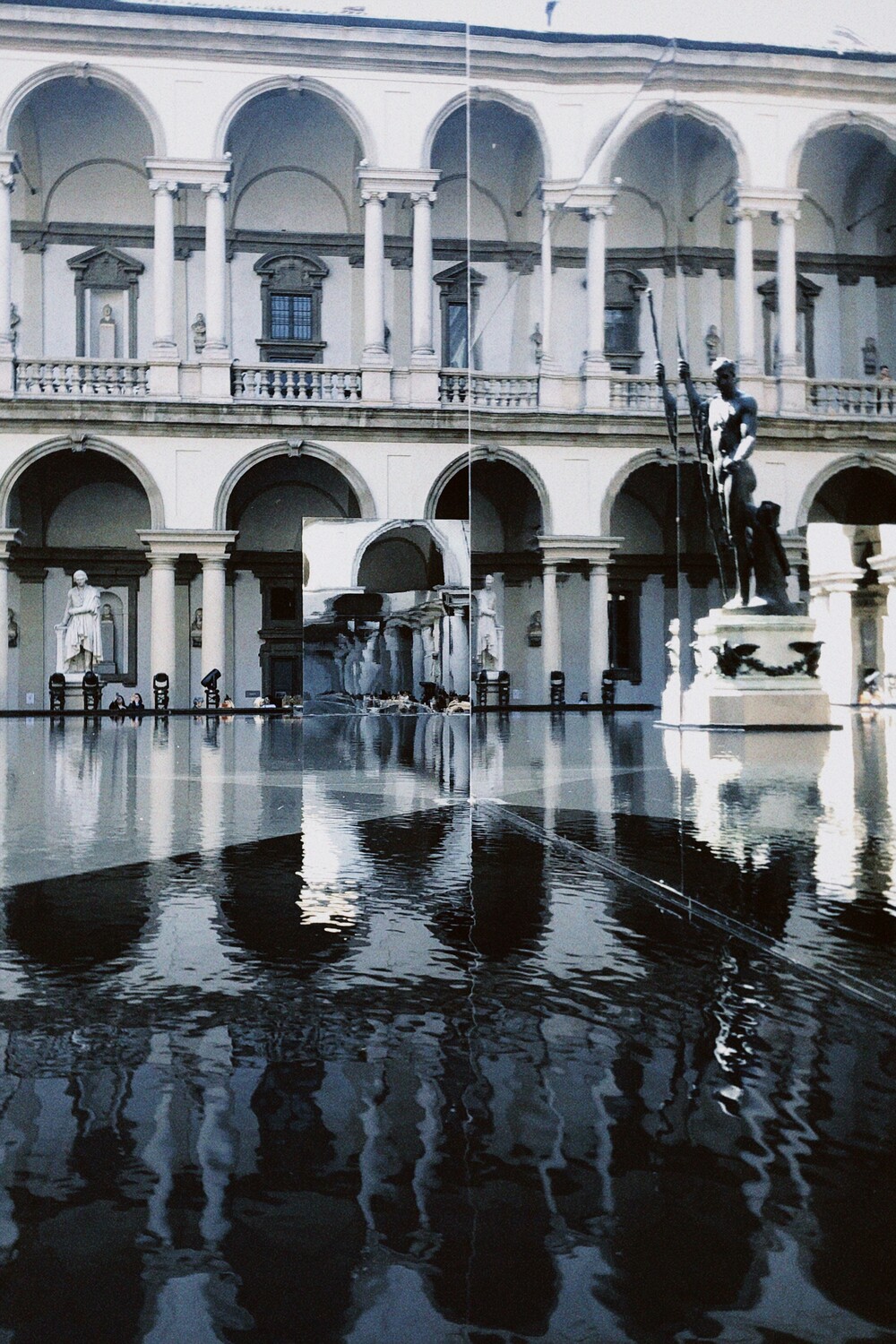 Courtyard of the Pinacoteca di Brera with a reflective water pool and statues, setting of the GROHE SPA