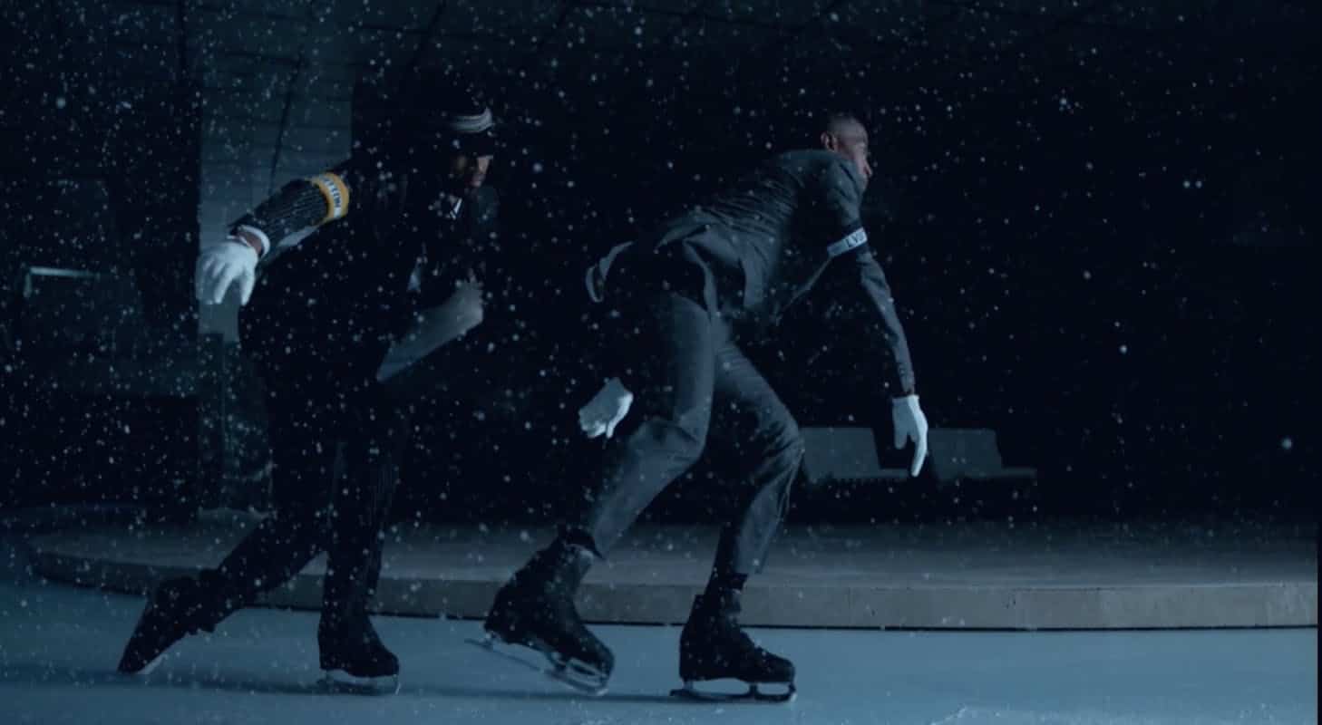 Zwei Models in dunklen Anzügen laufen Schlittschuh in einer Schneesimulation bei der Louis-Vuitton-Show.